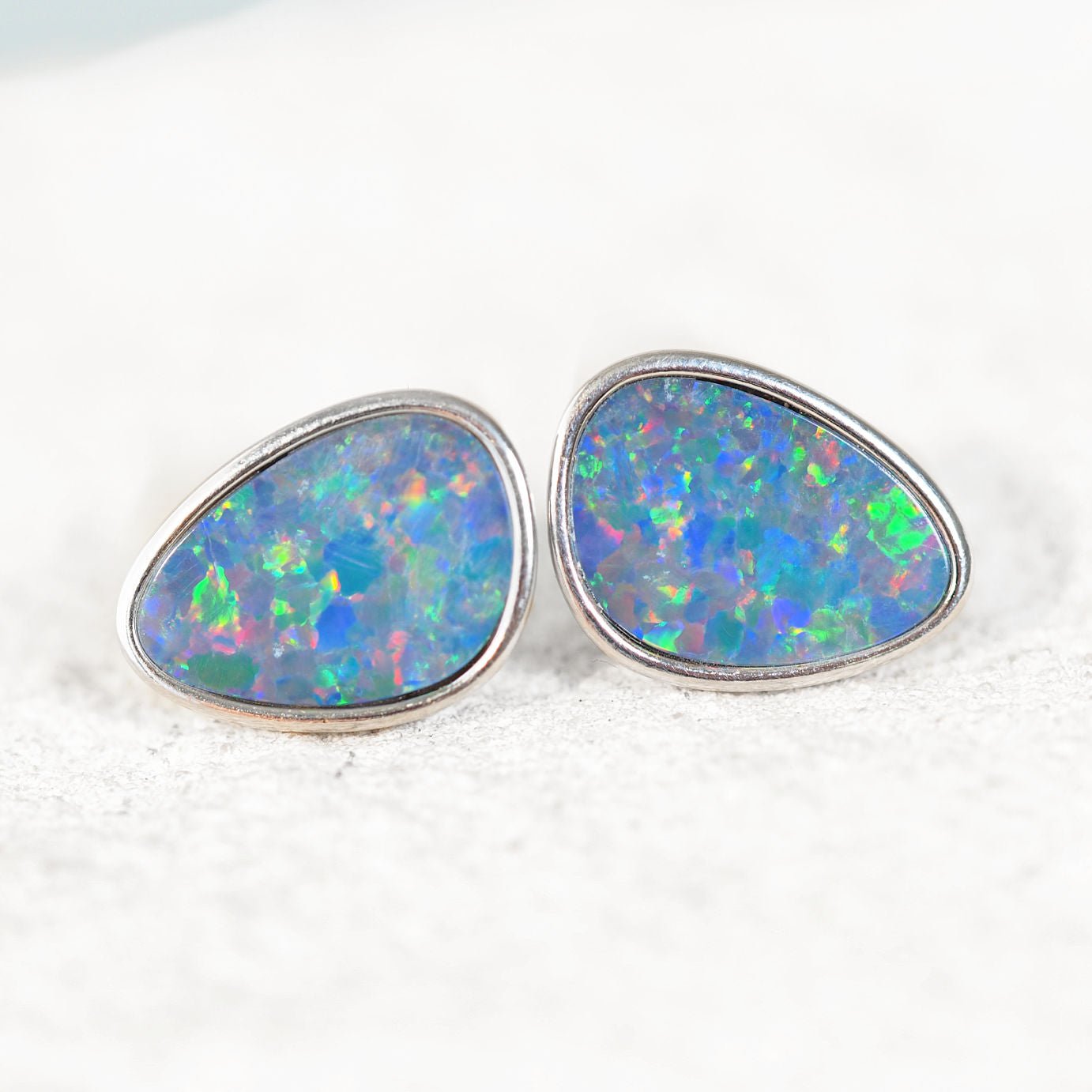 Opal earrings with a silver setting on a white background