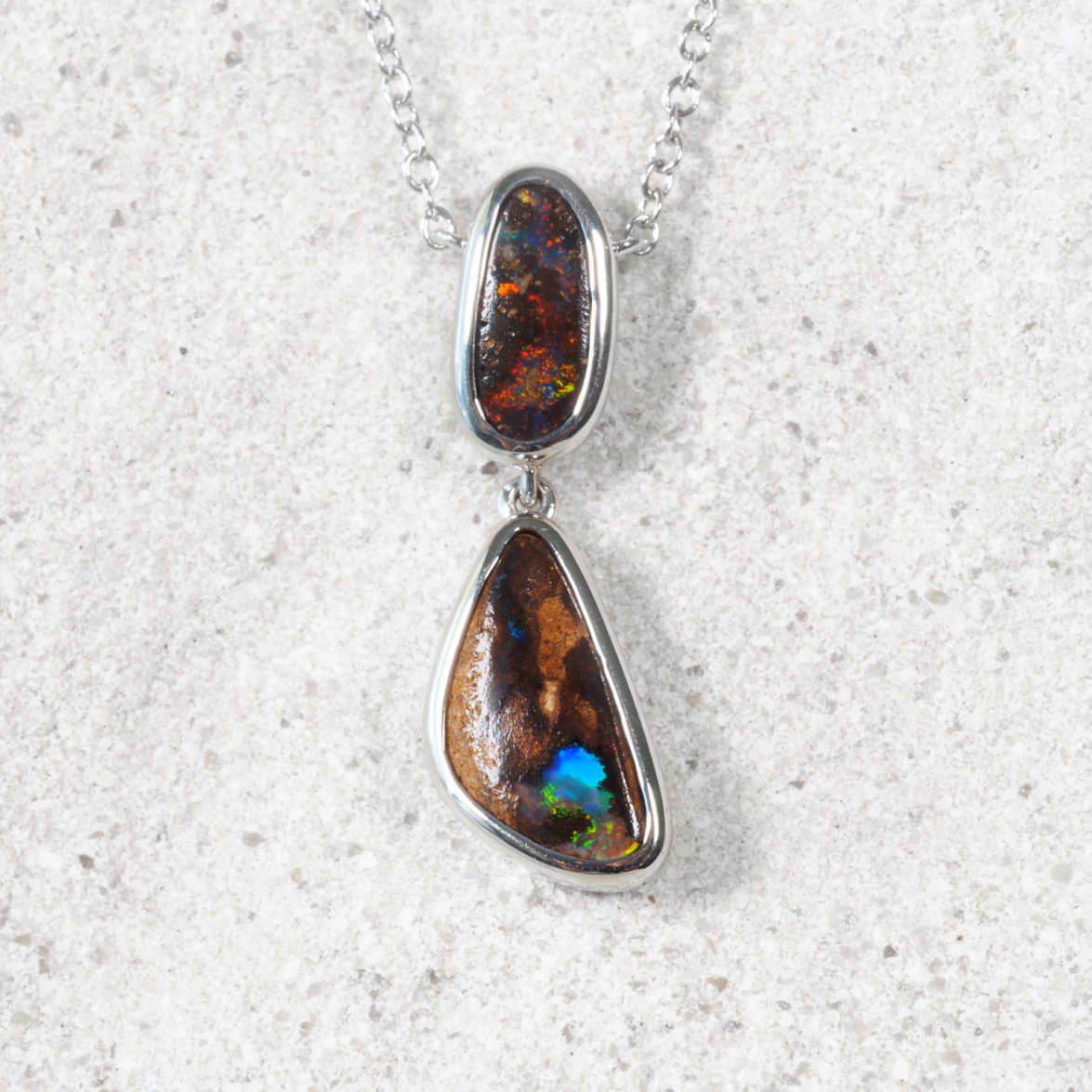 Opal pendant necklace on a textured white background