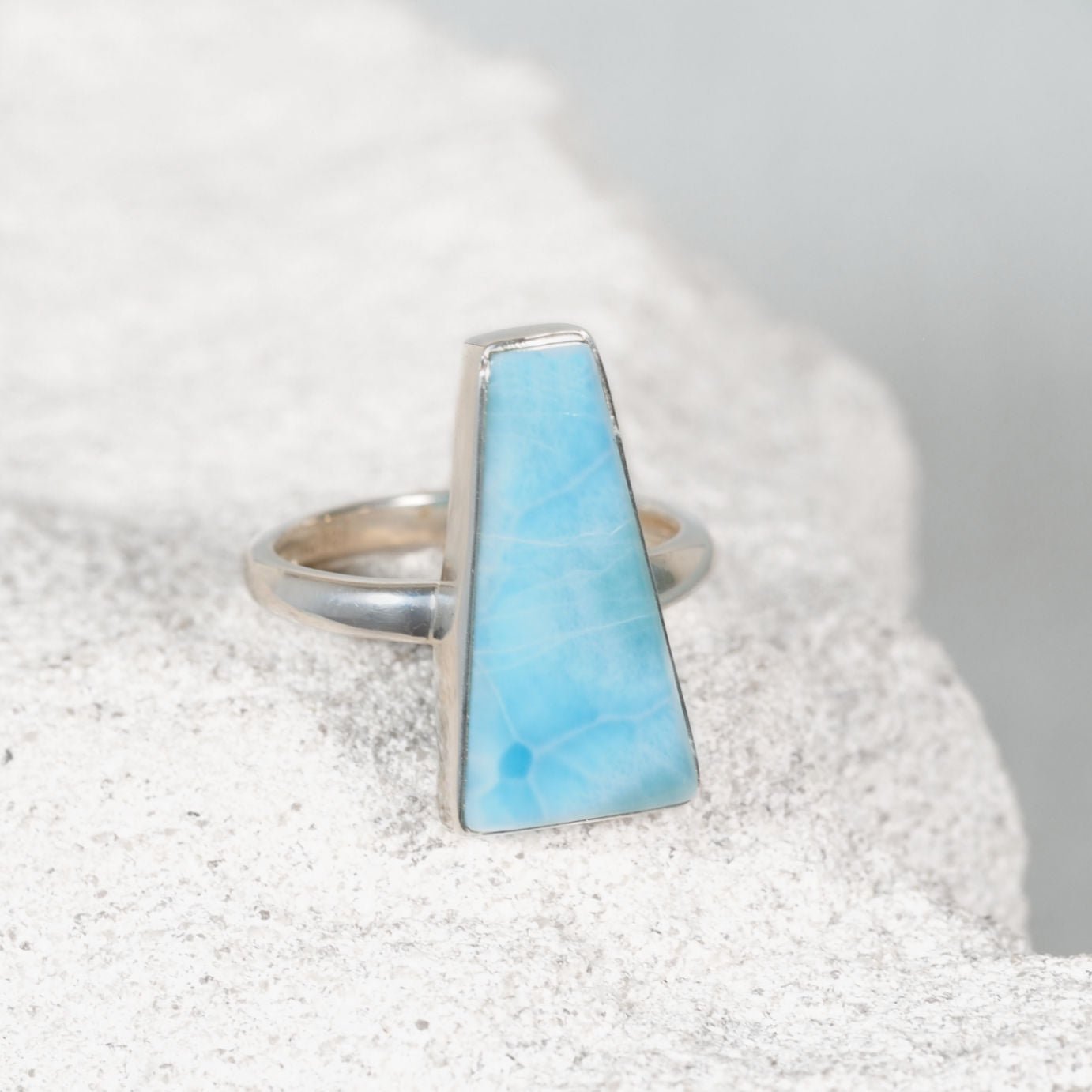‘Kehlani’ Larimar ring with a triangular blue cabochon and soft white accents, set in a polished silver bezel