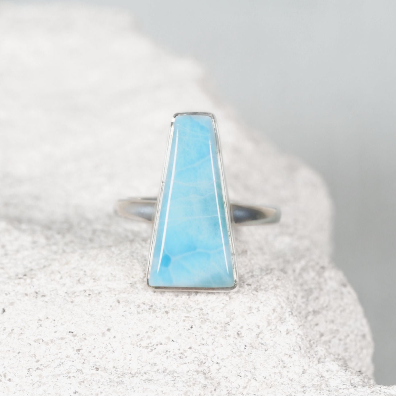Delicate triangular Larimar silver ring featuring gentle blue tones with subtle white streaks, minimalist design