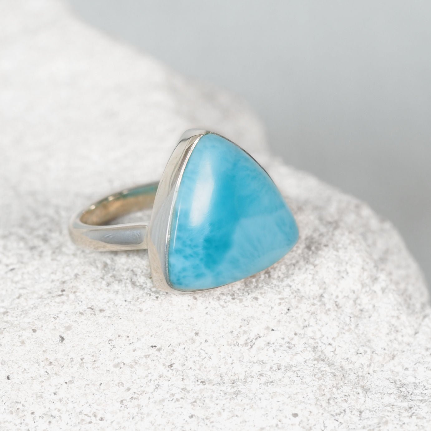 Triangular Larimar ring in polished silver with soft blue tones and white marbling