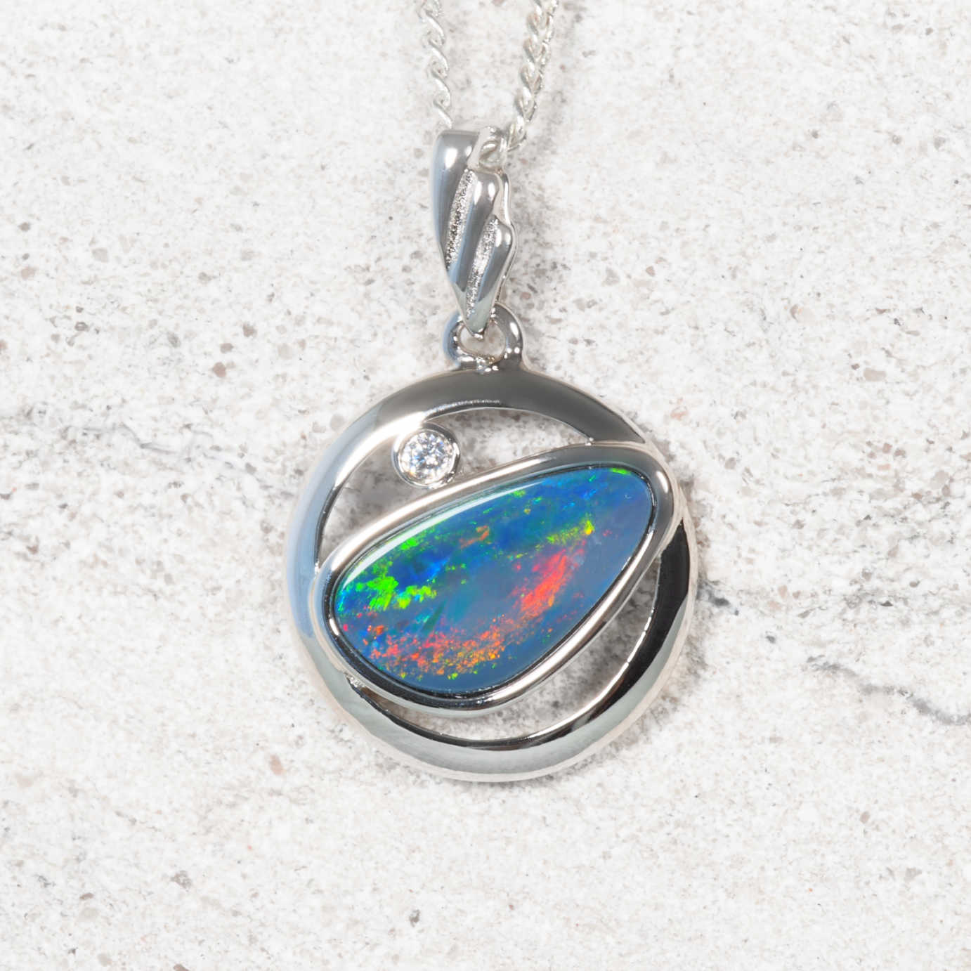 Opal pendant with silver setting on a white background