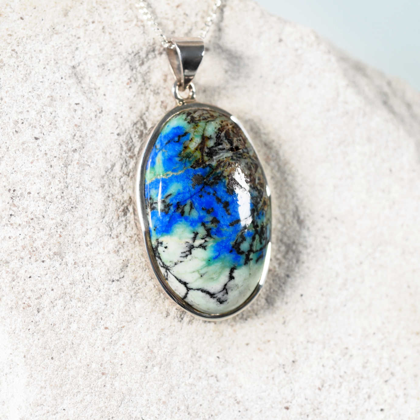 Close-up of 'Kira' pendant highlighting vibrant blue and green Azurite Chrysocolla gemstone in silver frame