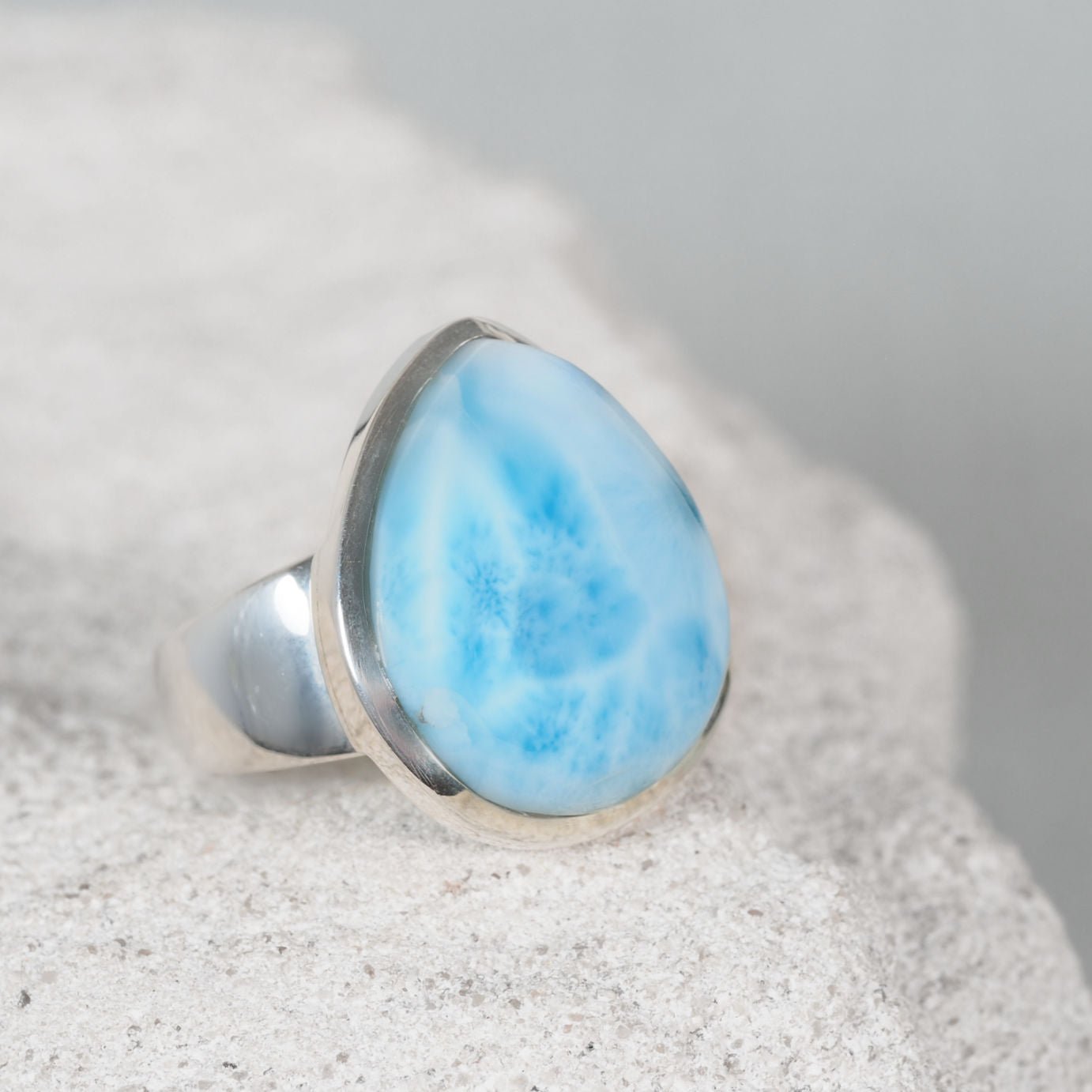 Silver ring featuring a smooth teardrop-shaped Larimar gemstone with natural ocean-inspired hues
