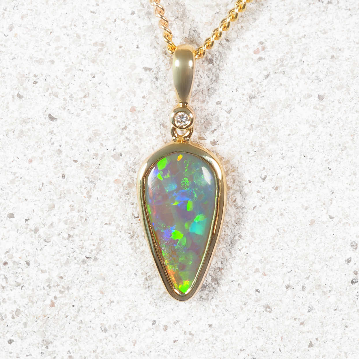 Opal pendant necklace on a textured white surface