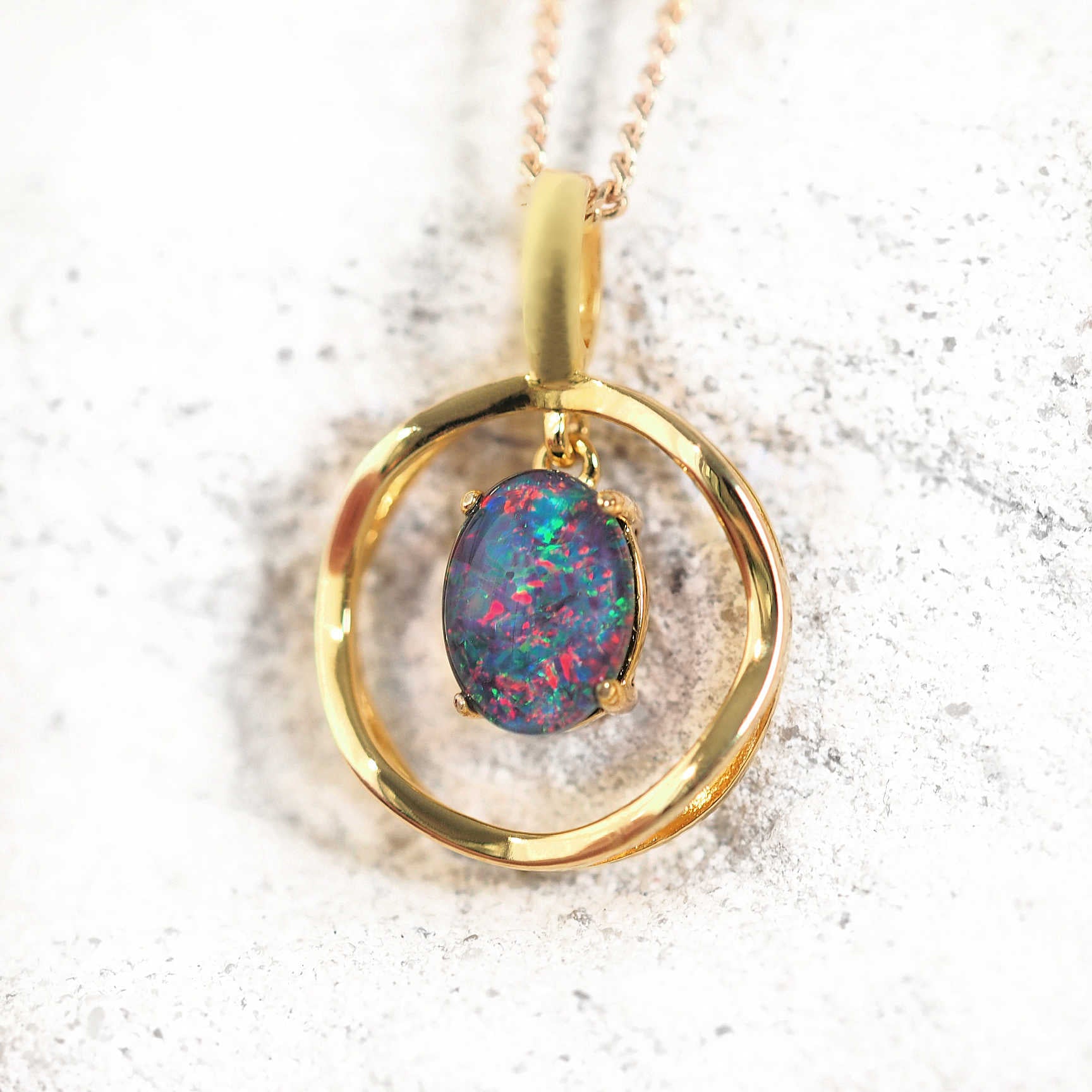 Gold-plated silver drop-style opal pendant necklace with claw-set multi-coloured Australian triplet opal in a double-layered circular design, shown with matching chain.

