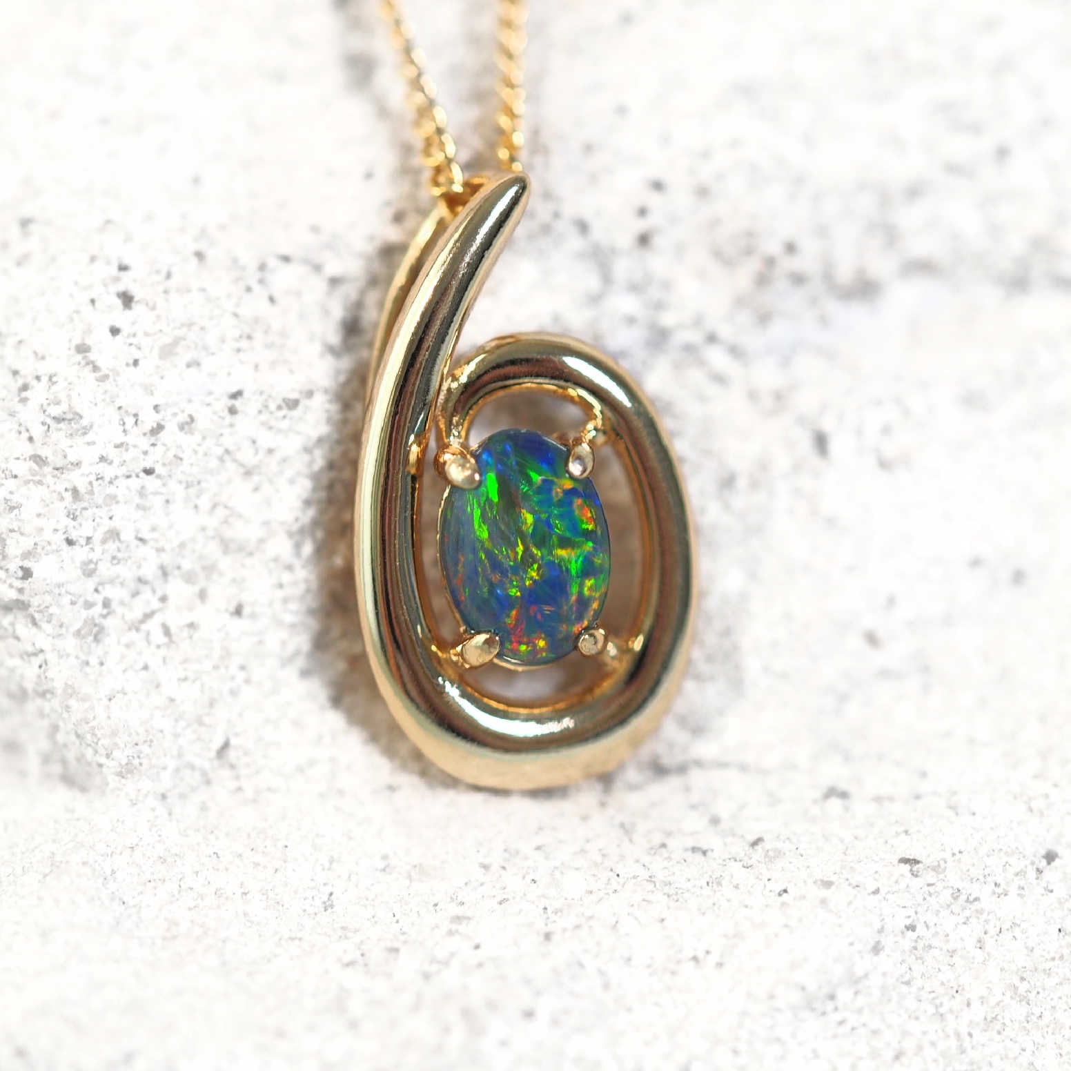 Gold-plated silver circular opal slide pendant necklace with claw-set Australian triplet opal in red, blue, and green tones, shown with matching chain.