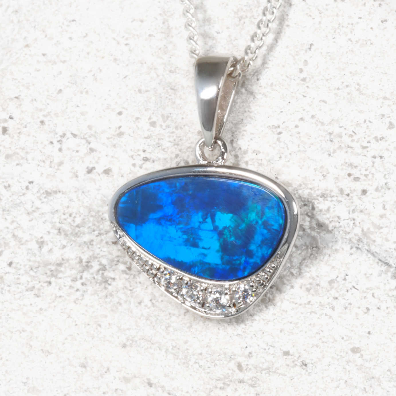 Blue opal pendant necklace on a textured white background