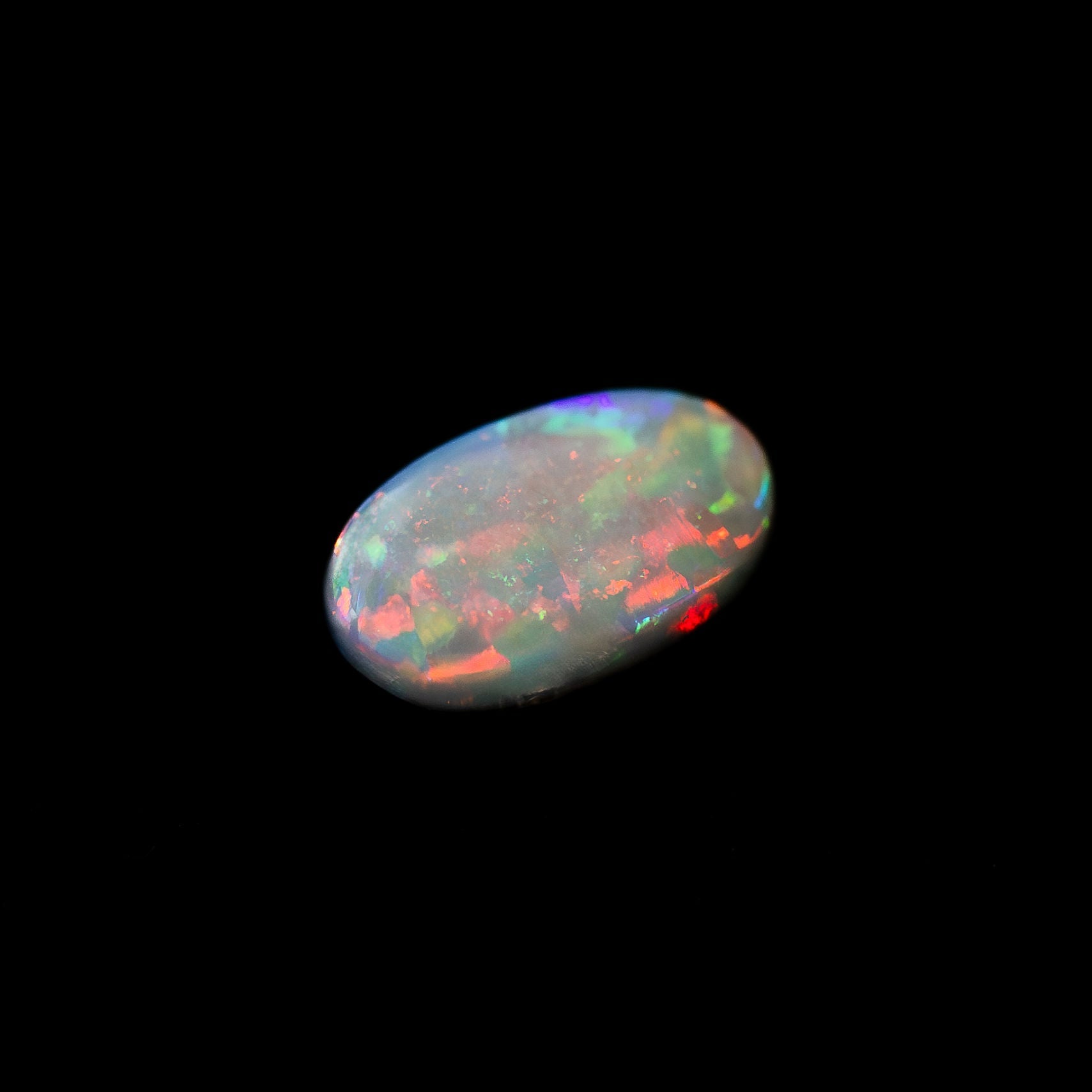 Colourful black opal stone on a black background