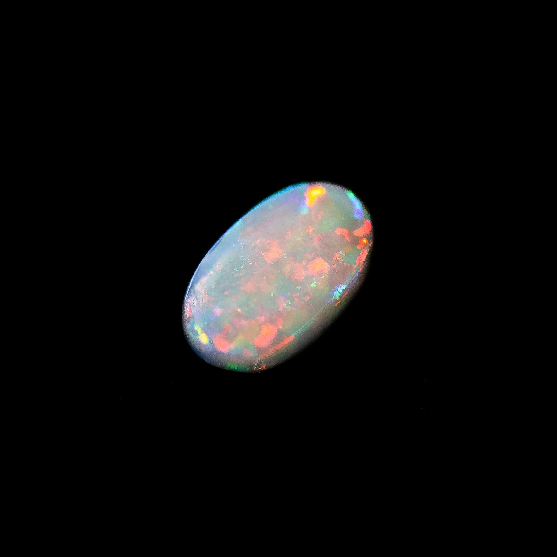Multicolored Black opal stone on a black background
