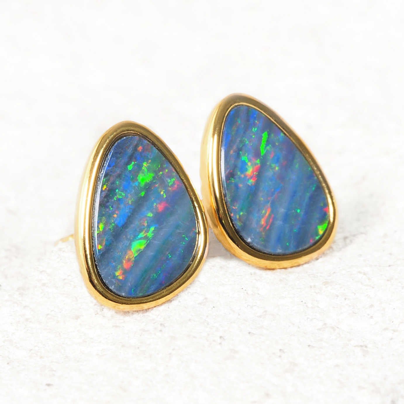 Gold plated silver Australian opal stud earrings with matching teardrop opal doublets displaying vibrant diagonal flashes of blue, green and red