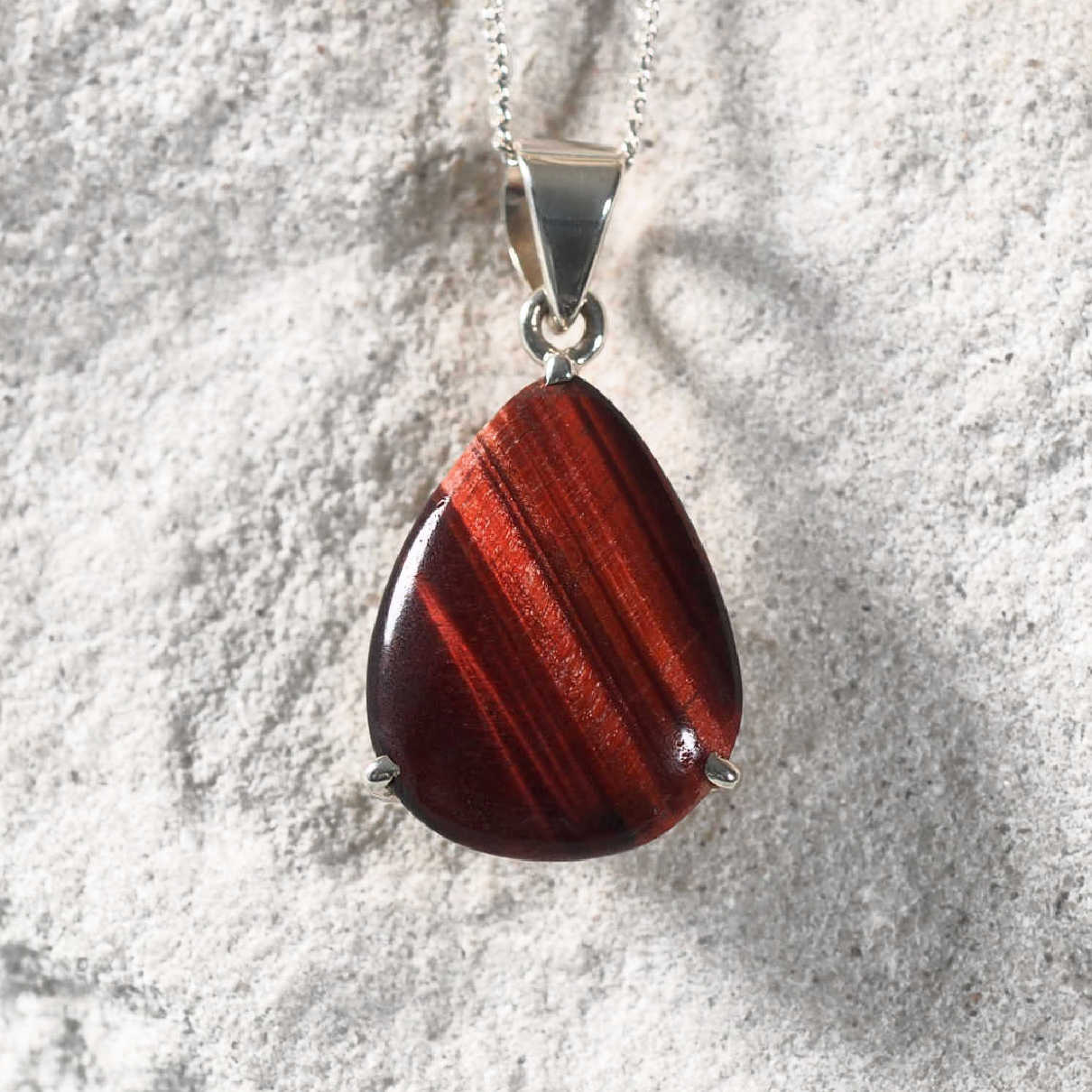 Sterling silver teardrop pendant with Red Tiger Eye gemstone in deep red tones.