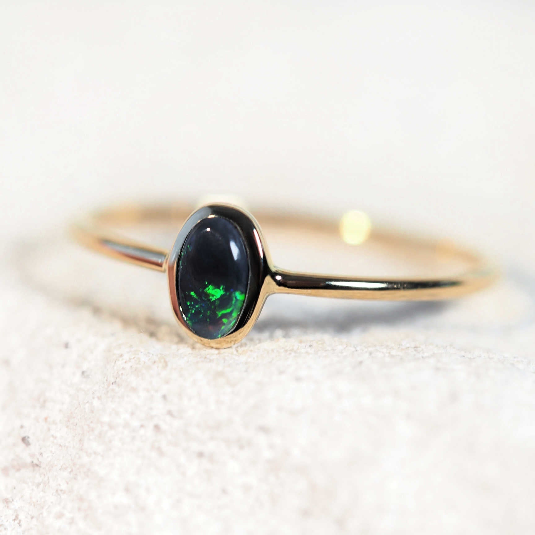 Solid black opal ring in classic bezel setting with slim yellow gold band