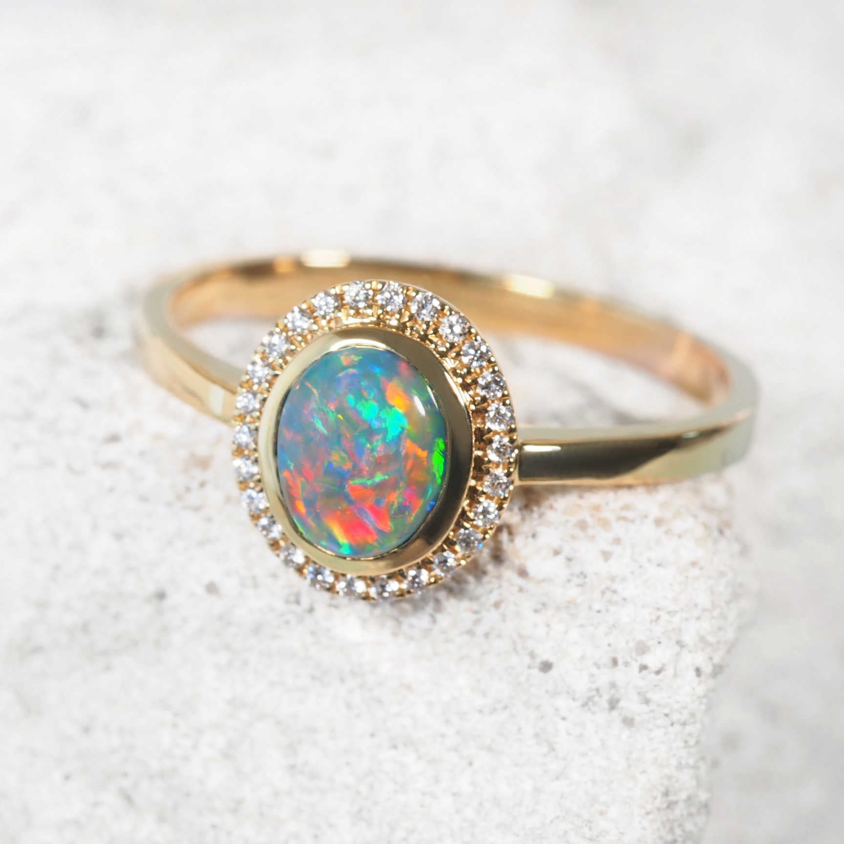 'Mairi' black opal ring with vivid multicolour Lightning Ridge opal and diamond halo in 18ct yellow gold