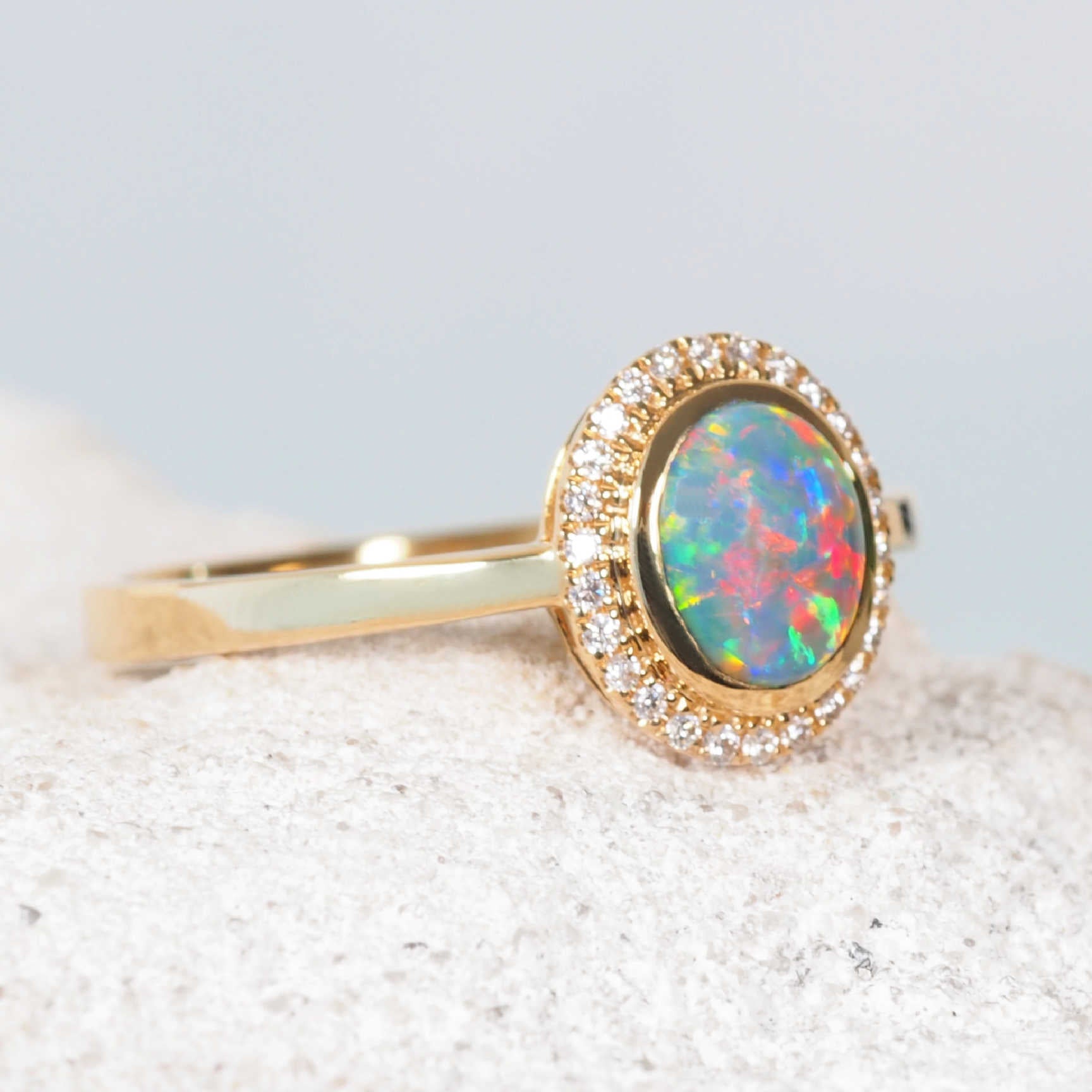 Close-up of Lightning Ridge black opal with flashes of red, green, blue and yellow in 18ct gold ring

