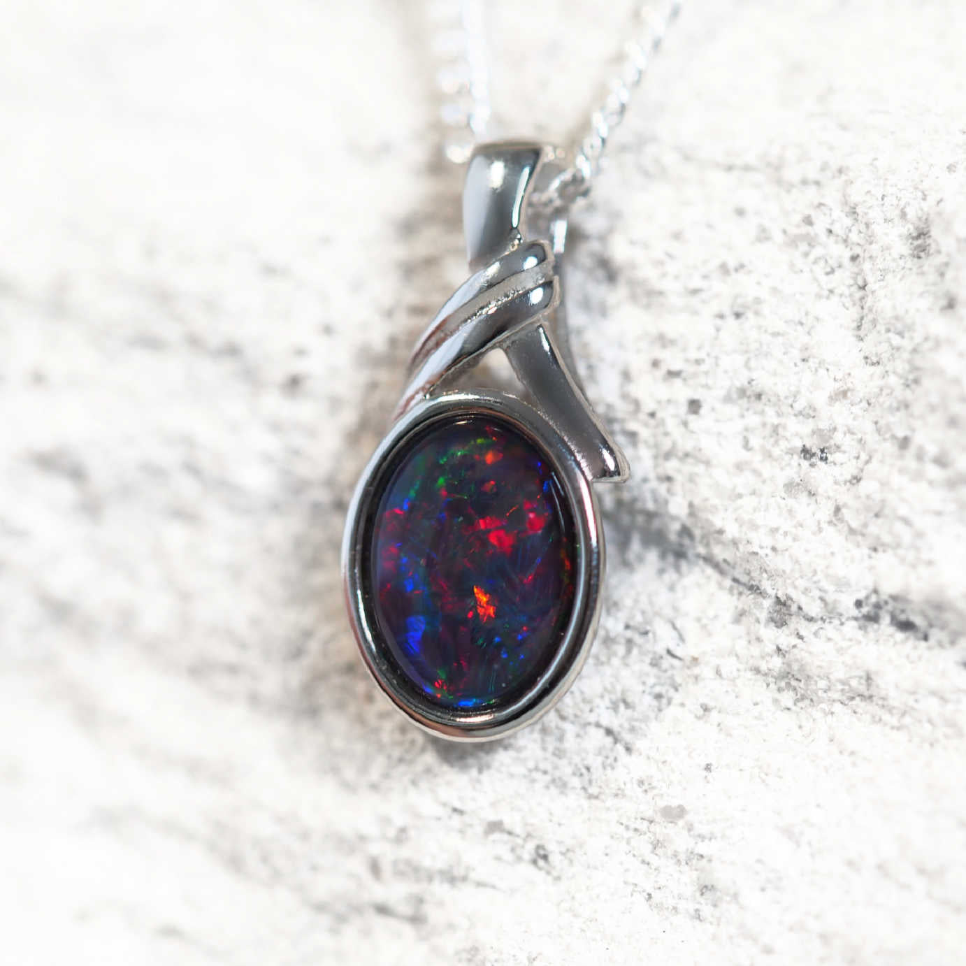 'Malia' opal pendant in sterling silver with decorative design and claw-set oval Australian triplet opal in vibrant multi-coloured tones