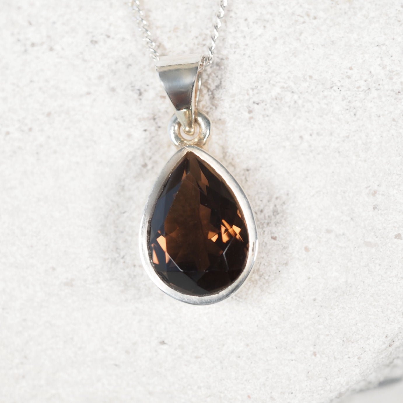 Close-up of the 'Mara' Smokey Quartz pendant with faceted teardrop stone set in a sleek silver frame