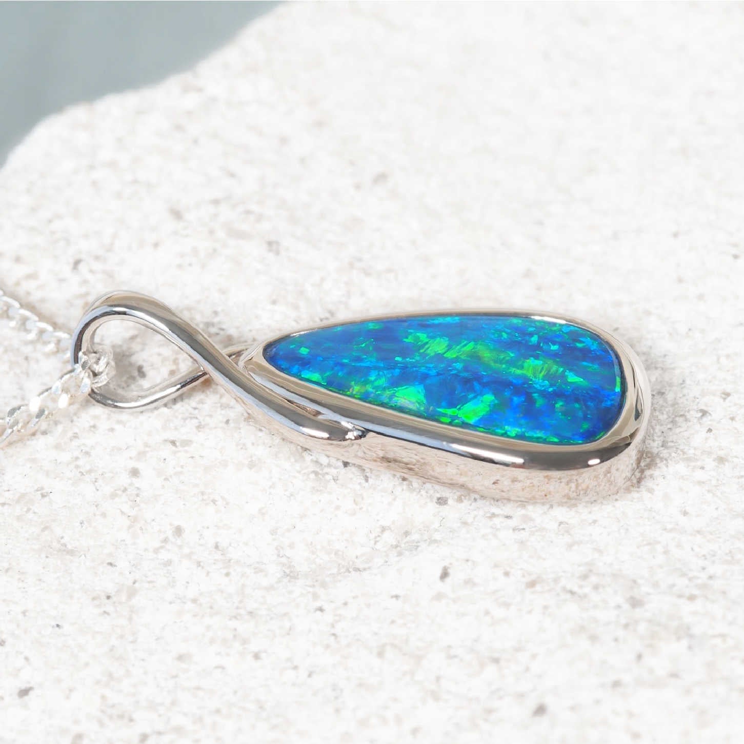 Australian opal pendant on a silver chain against a white background