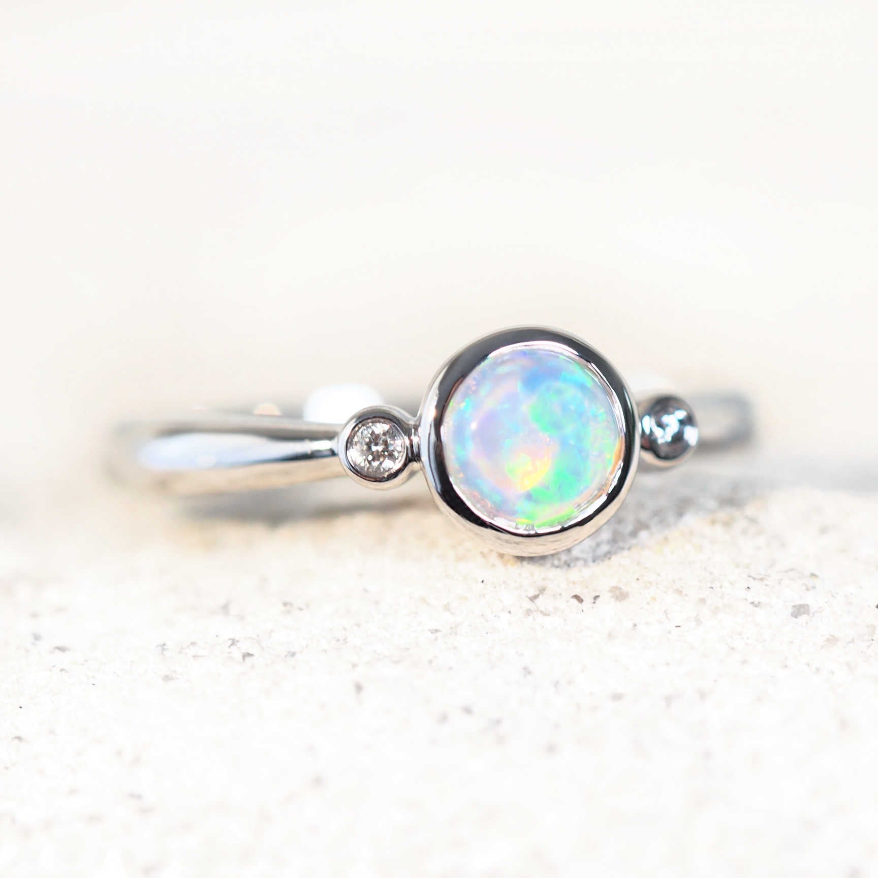 Round green crystal opal ring in 14ct white gold with diamond shoulders