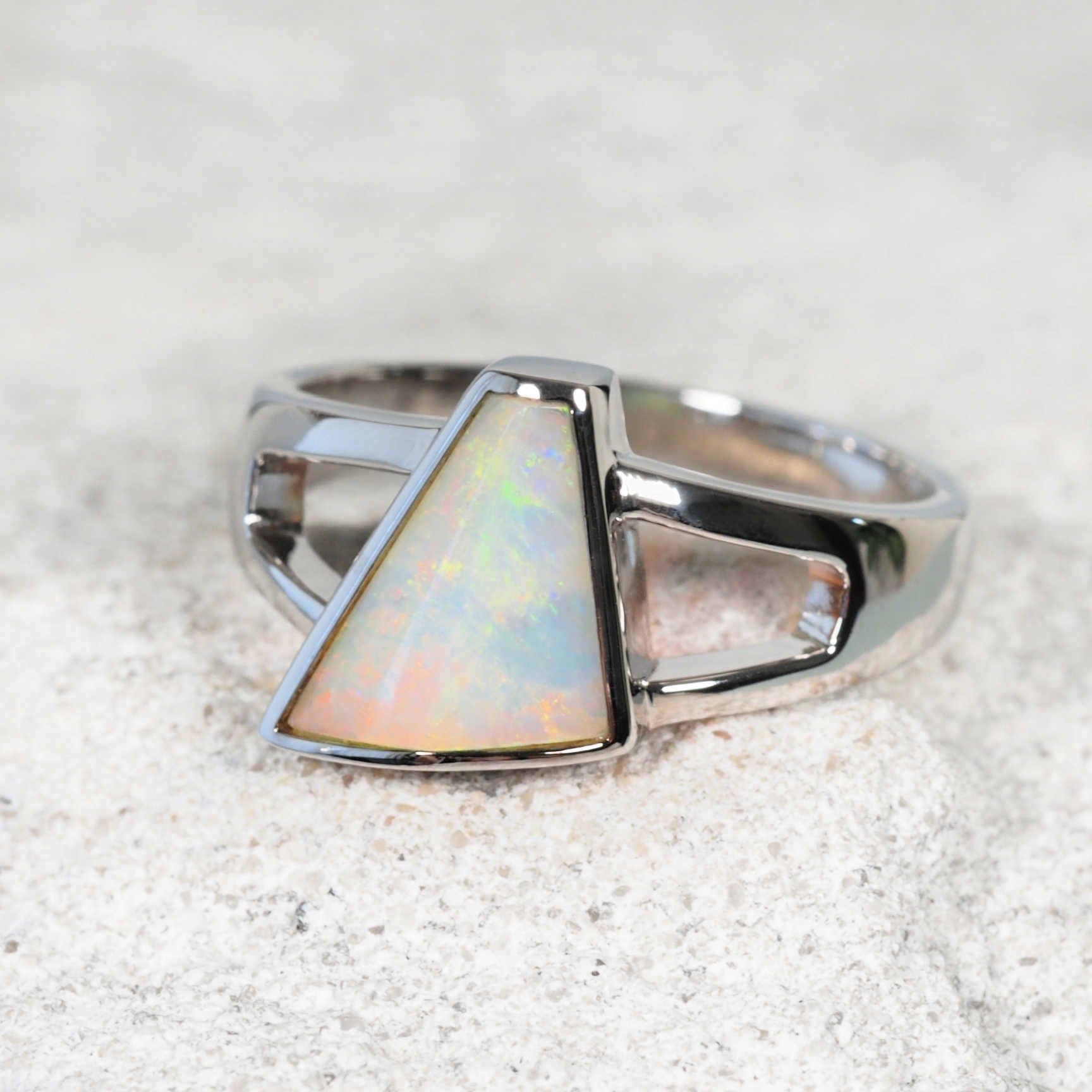 Close-up of bezel-set opal ring showing play-of-colour
