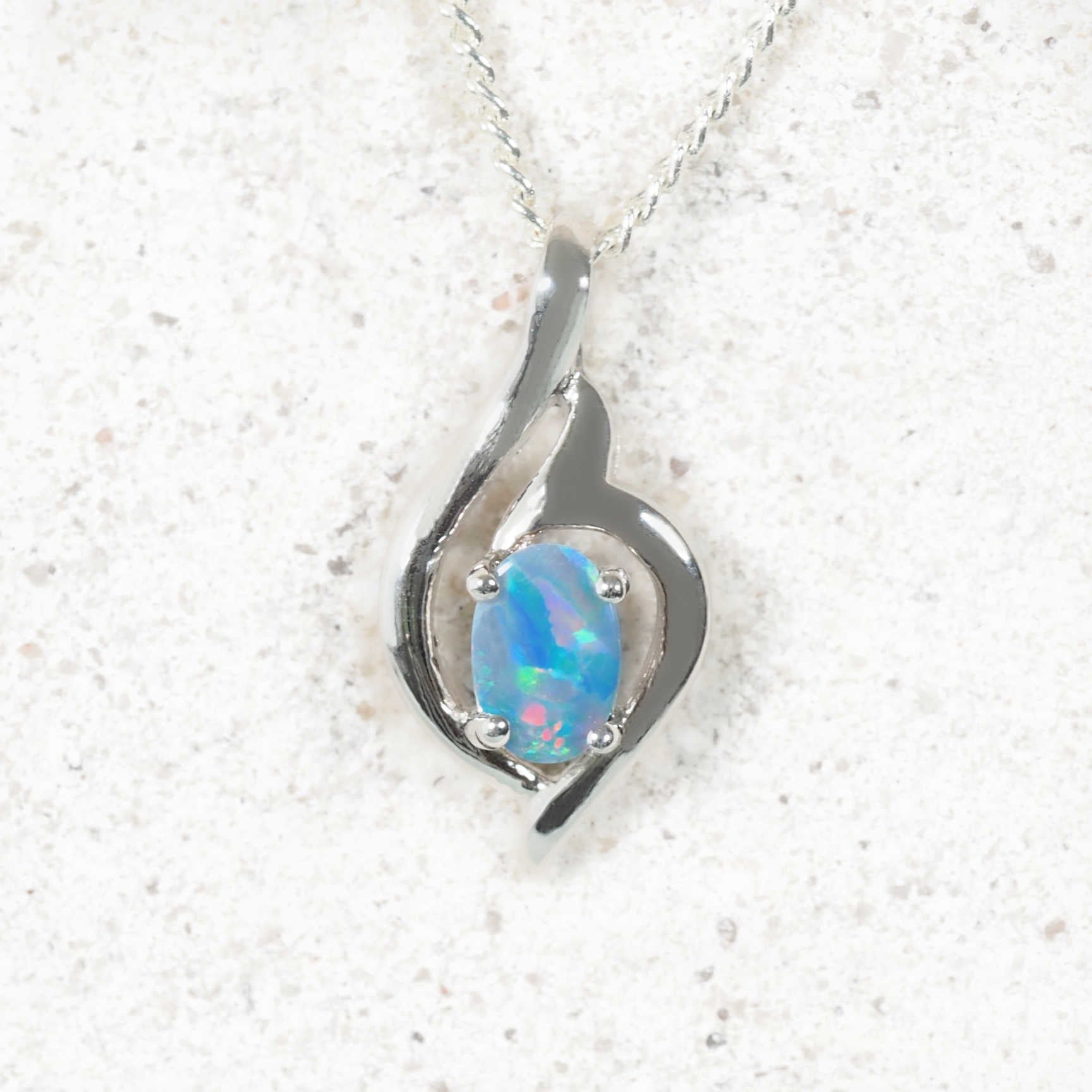 Contemporary bezel-set oval opal pendant in sterling silver with decorative design