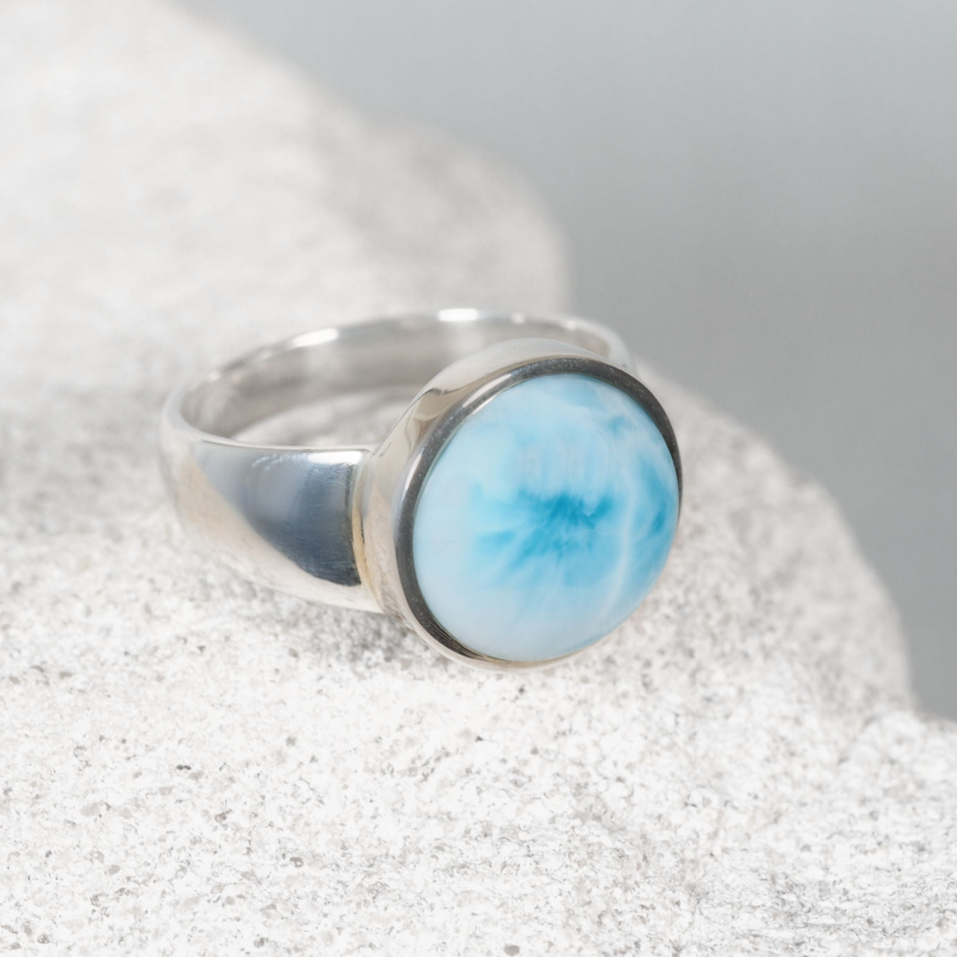 ‘Mila’ Blue Larimar ring showcasing a round blue gemstone with a thin white line, set in polished silver