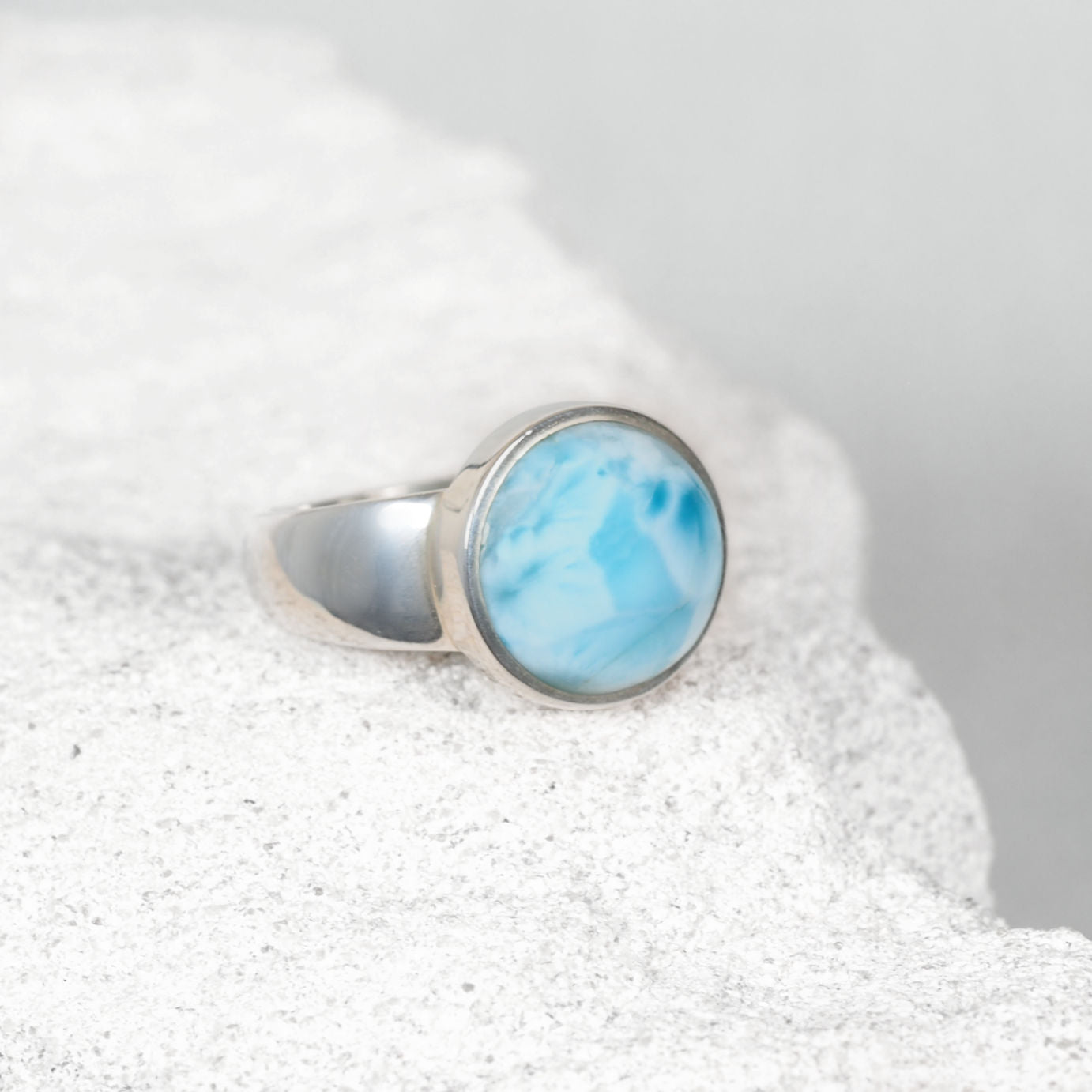 Small round Larimar silver ring featuring gentle blue hues with subtle white wisps, minimalist design