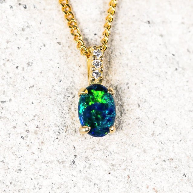 Gold-plated silver opal pendant with an oval blue and green Australian triplet opal and three cubic zirconias.