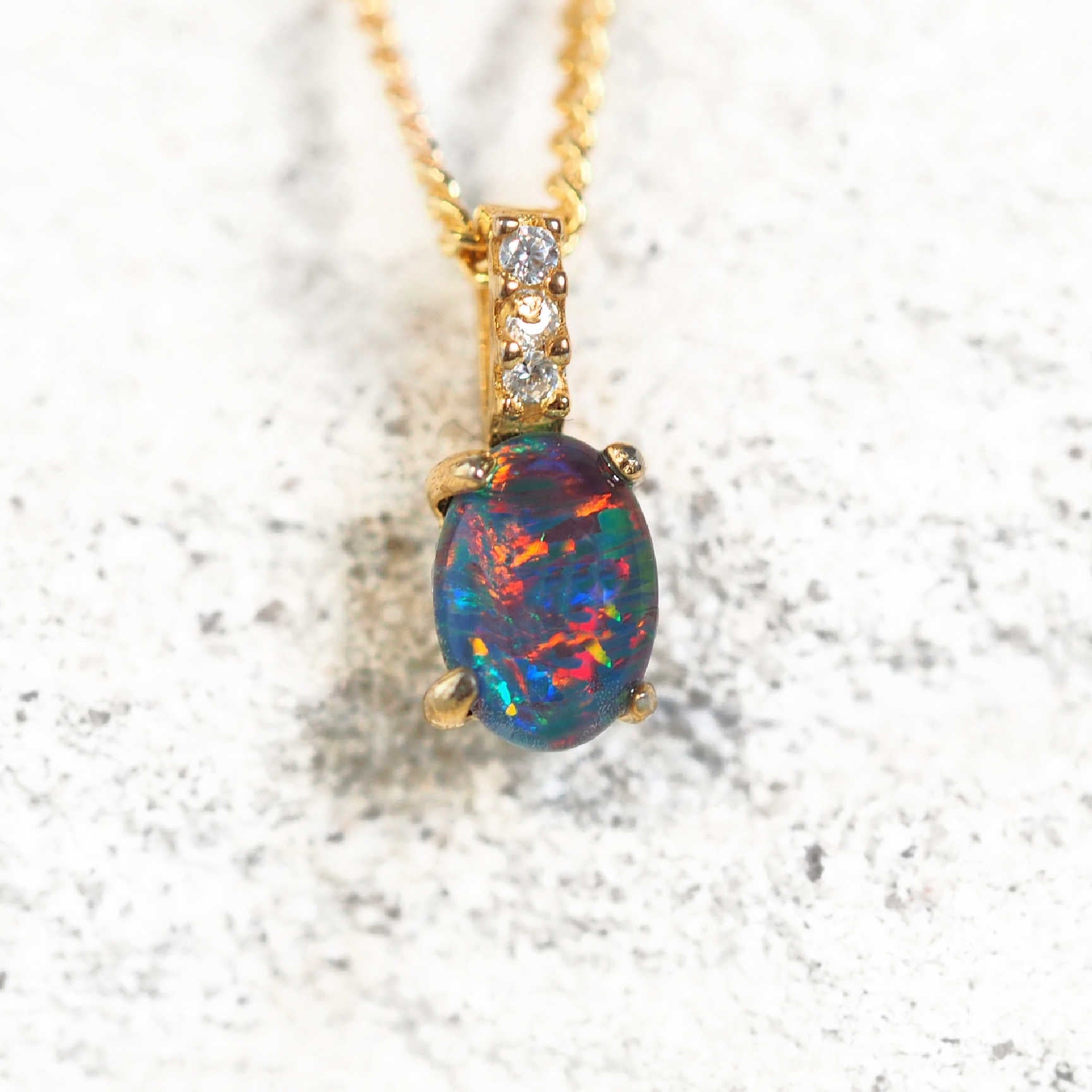 Gold plated silver opal necklace with oval Australian triplet opal and three cubic zirconias.