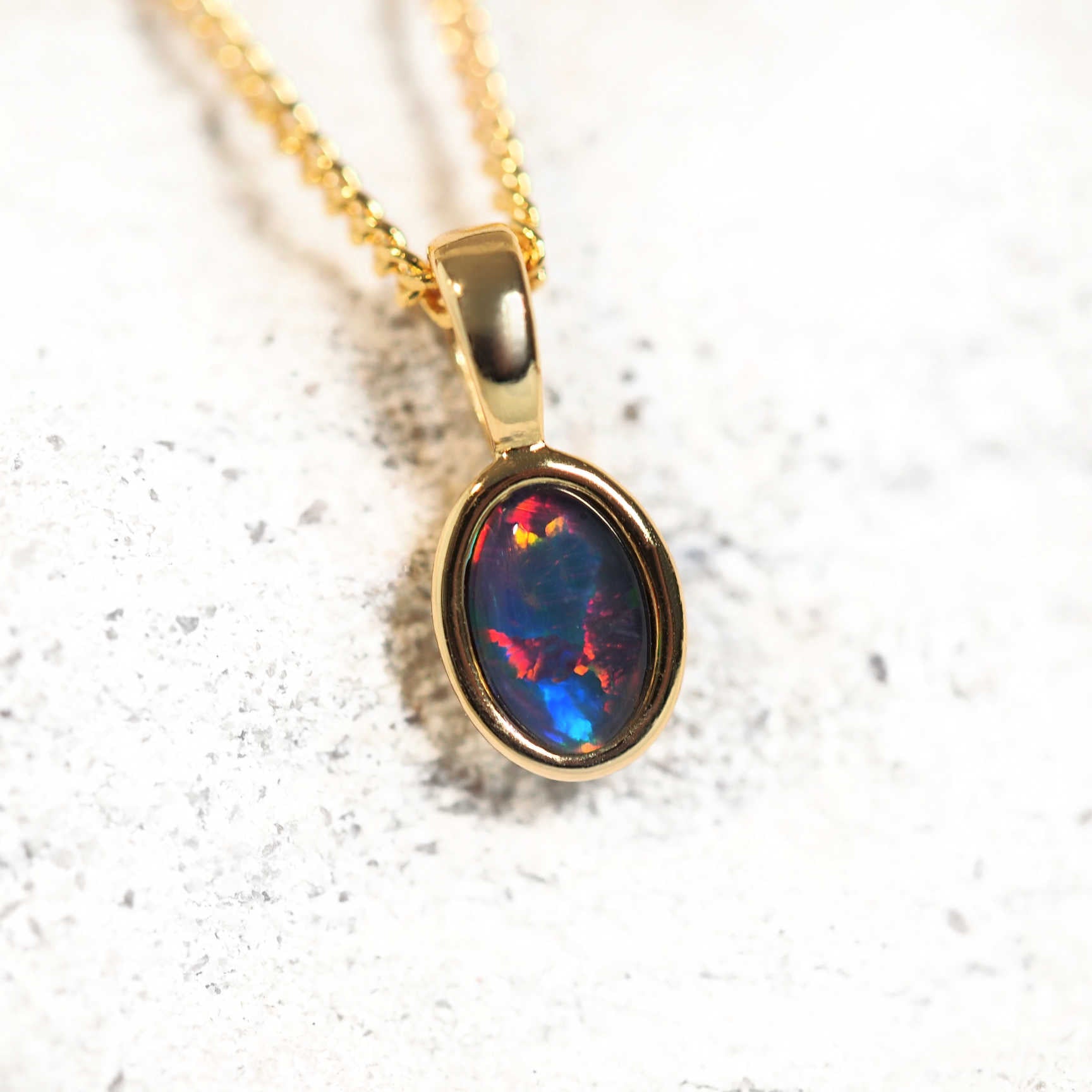 Myka Petite gold-plated silver opal pendant featuring a vibrant oval Australian triplet opal in a classic bezel setting.