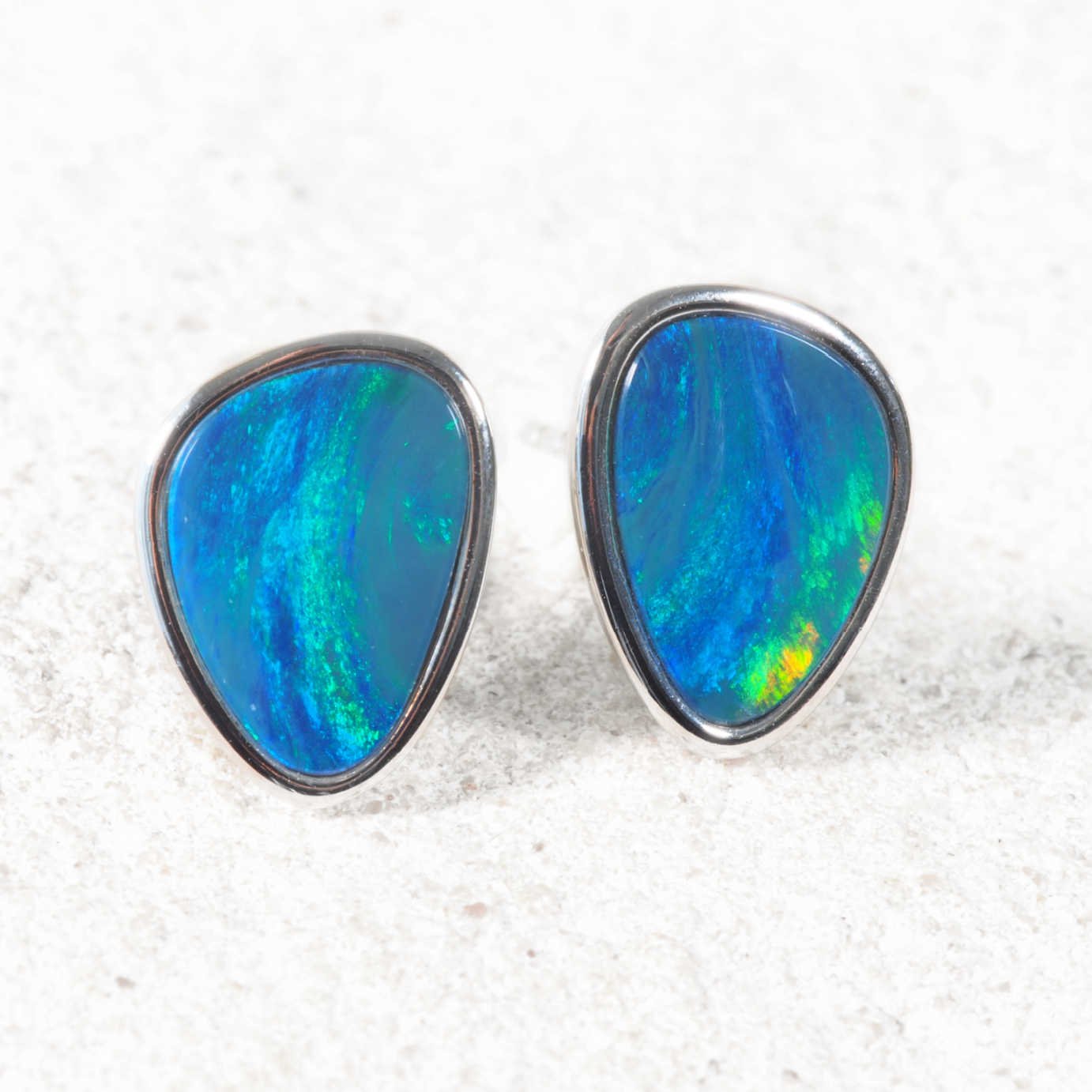 Sterling silver Australian opal stud earrings featuring matching teardrop-shaped opal doublets with vibrant blue and green flashes