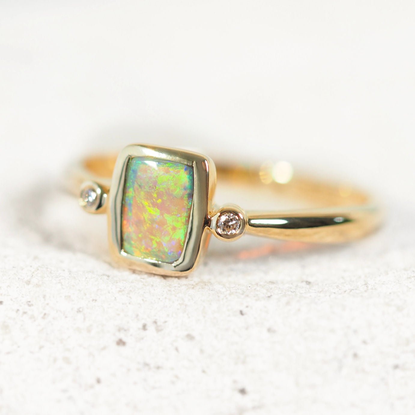 Rectangular bezel-set opal ring in 14ct yellow gold with green crystal opal and diamonds