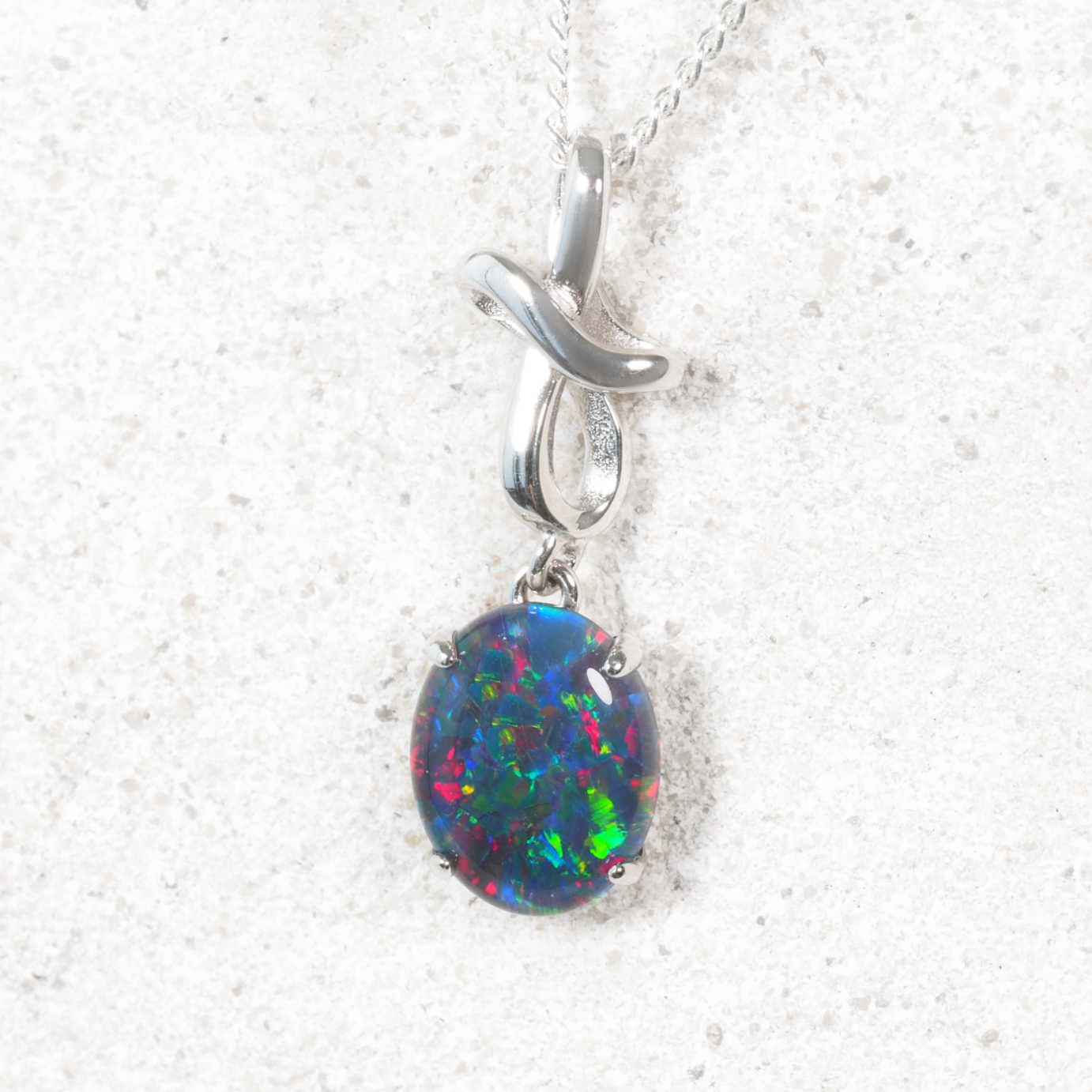 Opal pendant on a silver chain against a white background