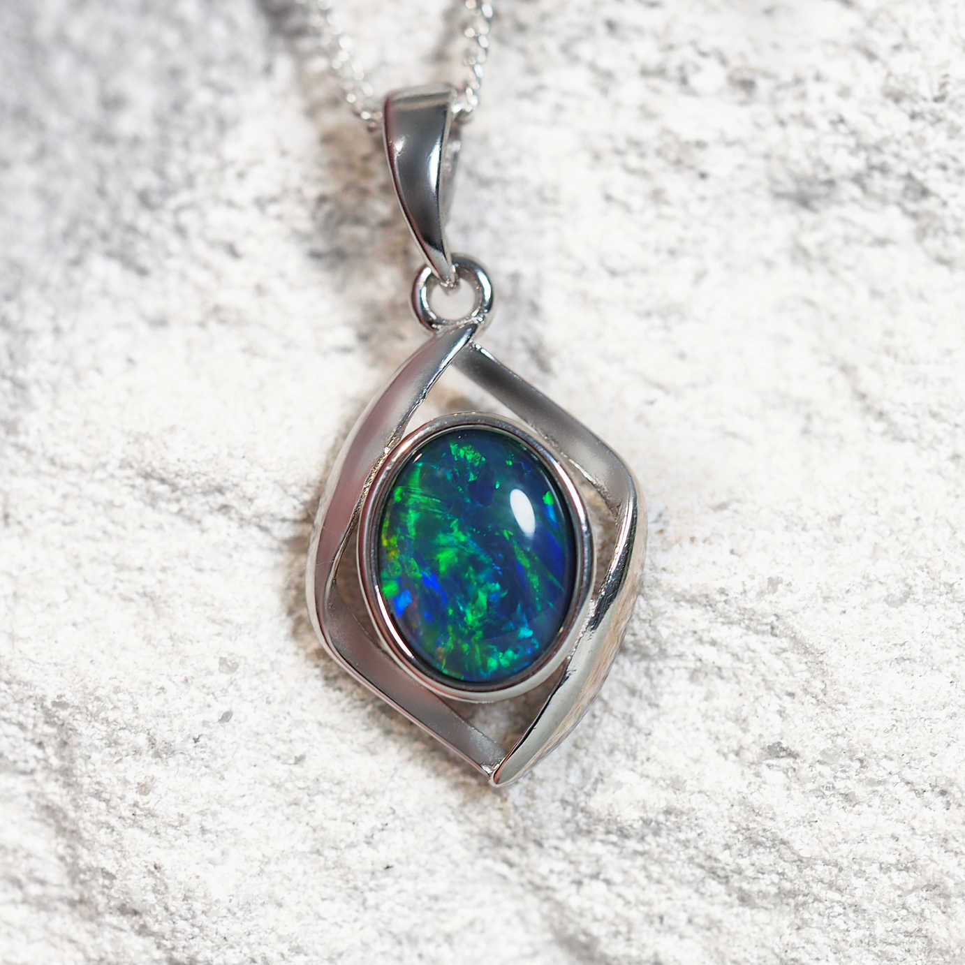 ‘Nova Blue’ sterling silver opal pendant with diamond-shaped frame and bezel-set oval Australian triplet opal in vibrant blue and green tones