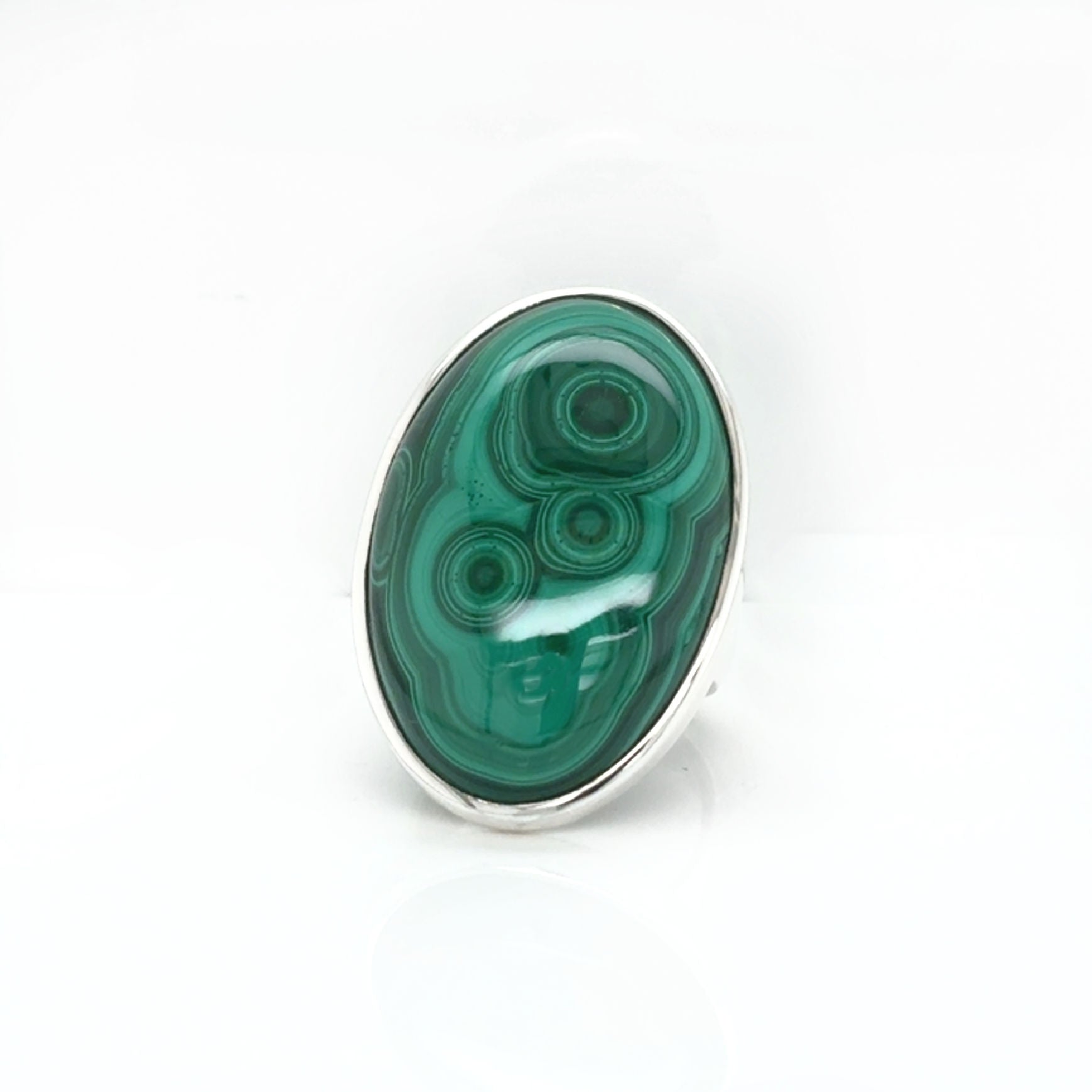 Green malachite stone with silver setting on a white background