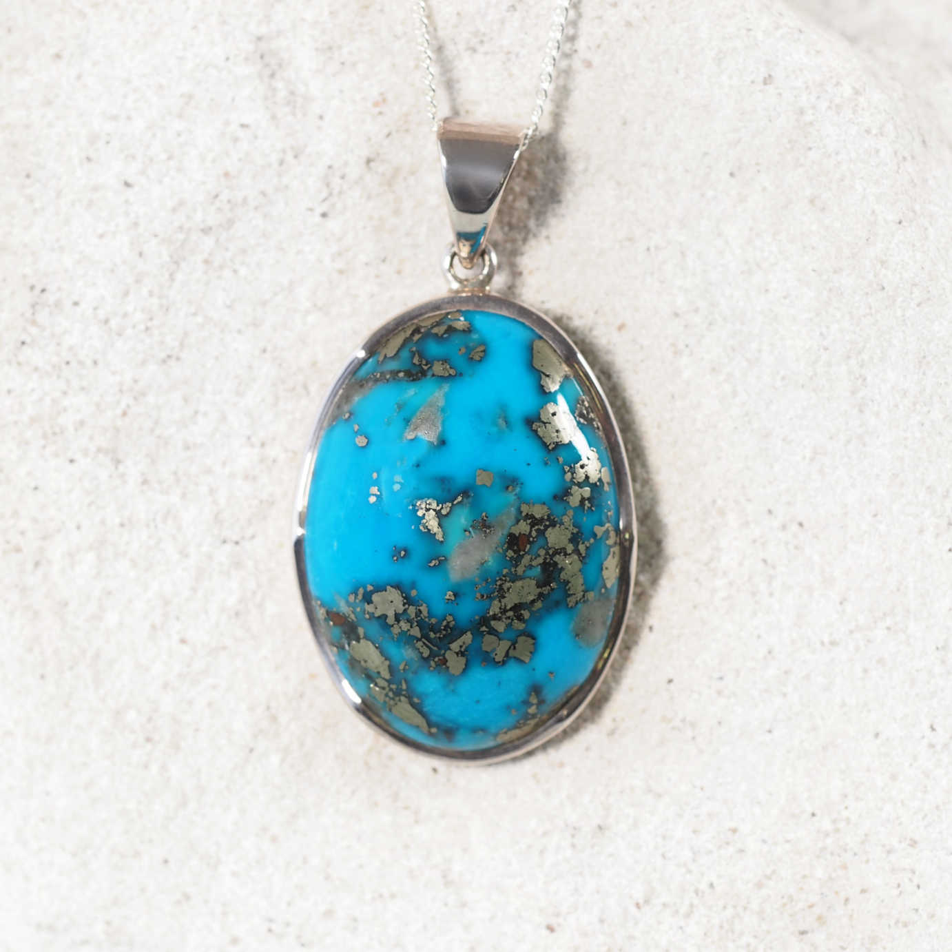 'Nyra' silver pendant with a Oval Persian turquoise gemstone, featuring bright blue tones and a polished cabochon cut.
