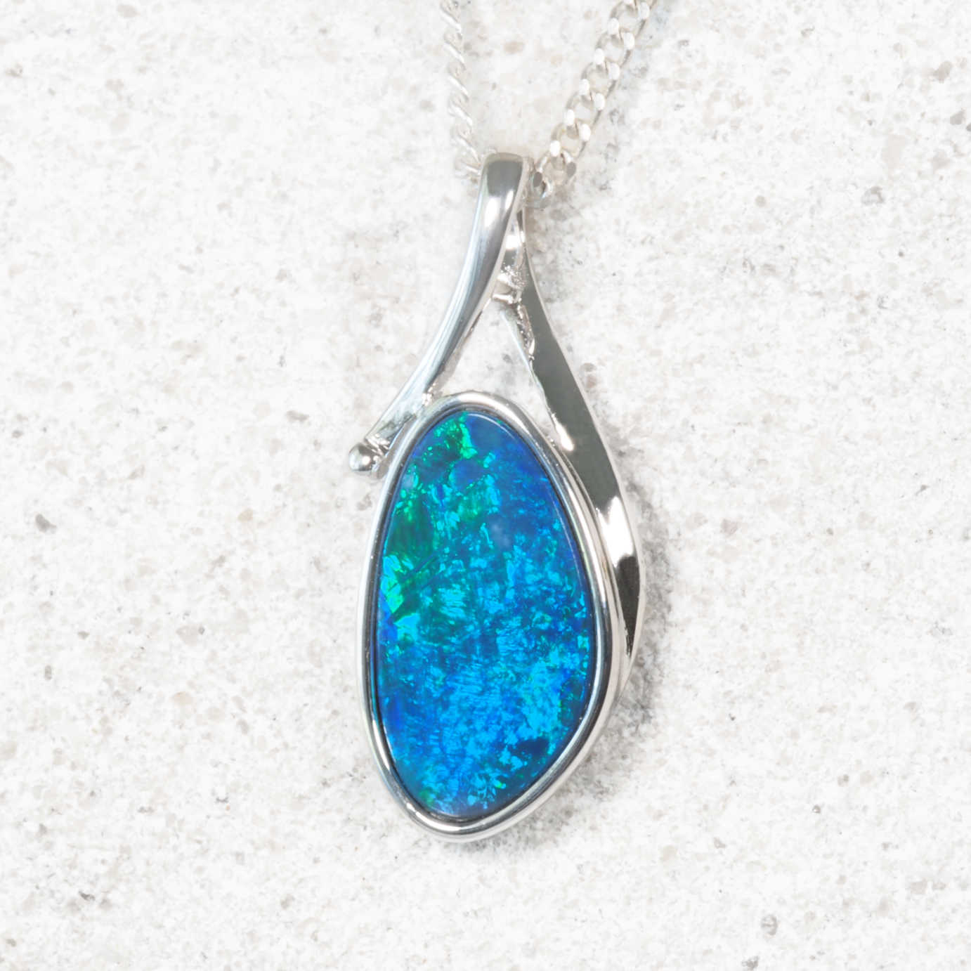 Blue opal pendant on a silver chain against a white background