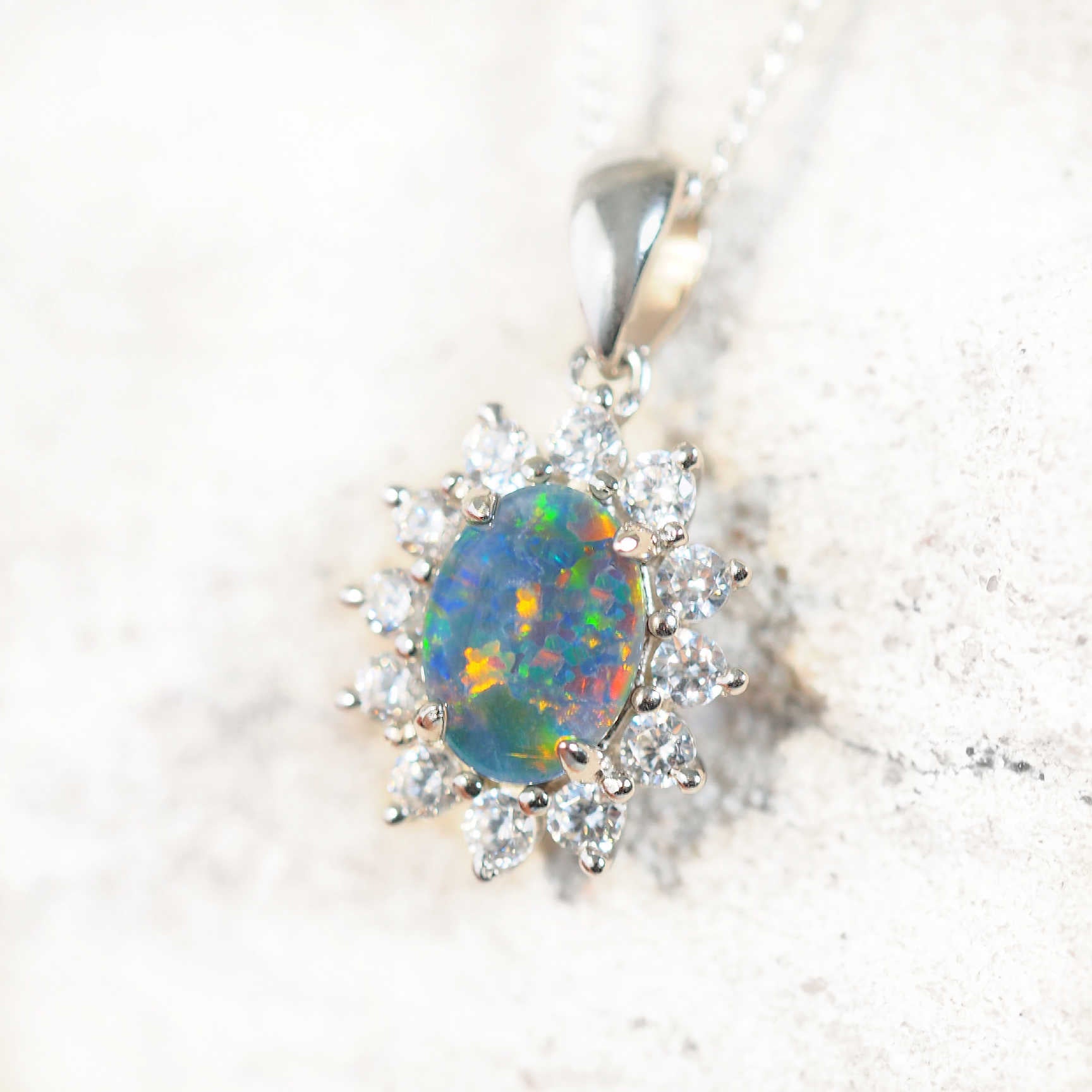 Silver triplet opal pendant set with cubic zirconias in a princess design