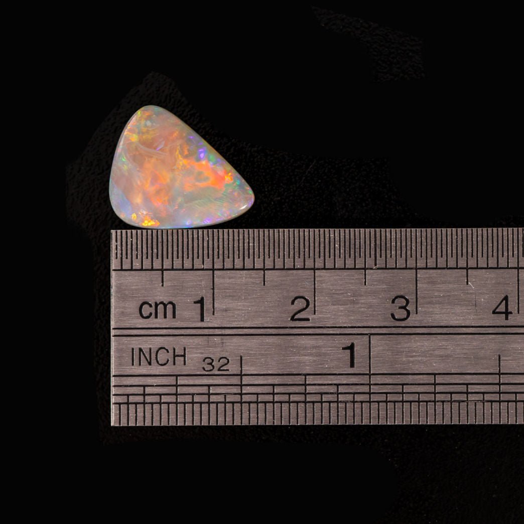 Rare triangular black opal stones with vivid play-of-colour on grey background