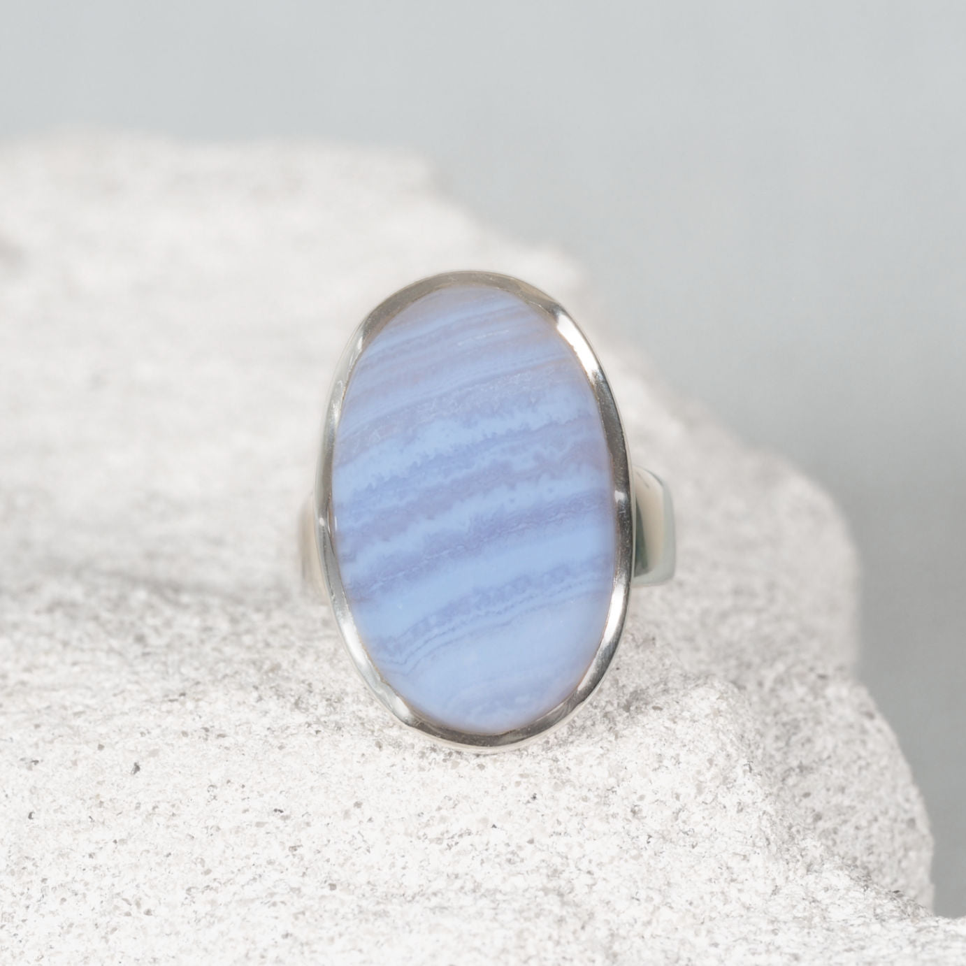 'Quinn' Blue Lace Agate silver ring, displaying soft blue hues on a sandy background