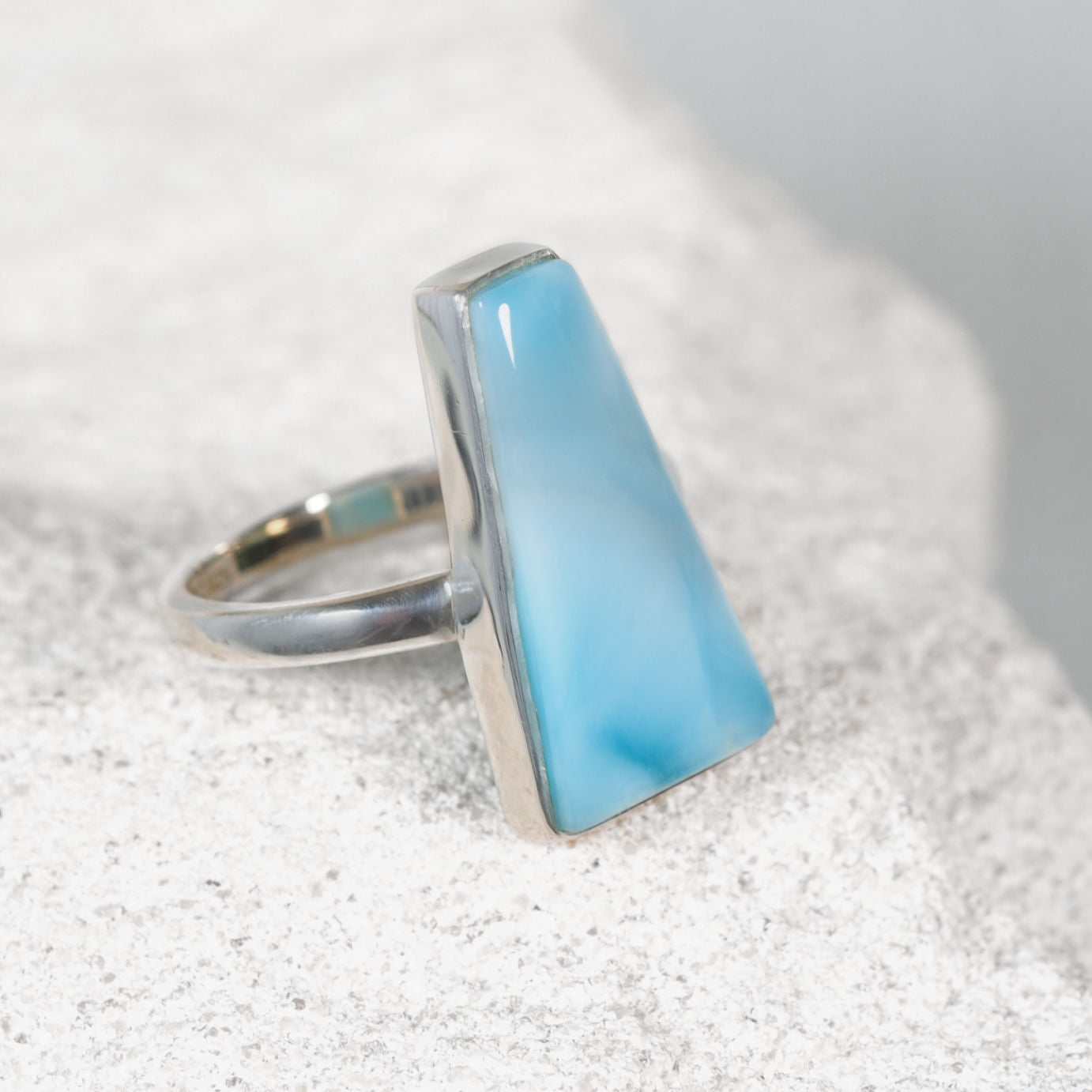 ‘Sadie’ Larimar ring featuring a triangular blue gemstone with a subtle white streak, set in polished silver
