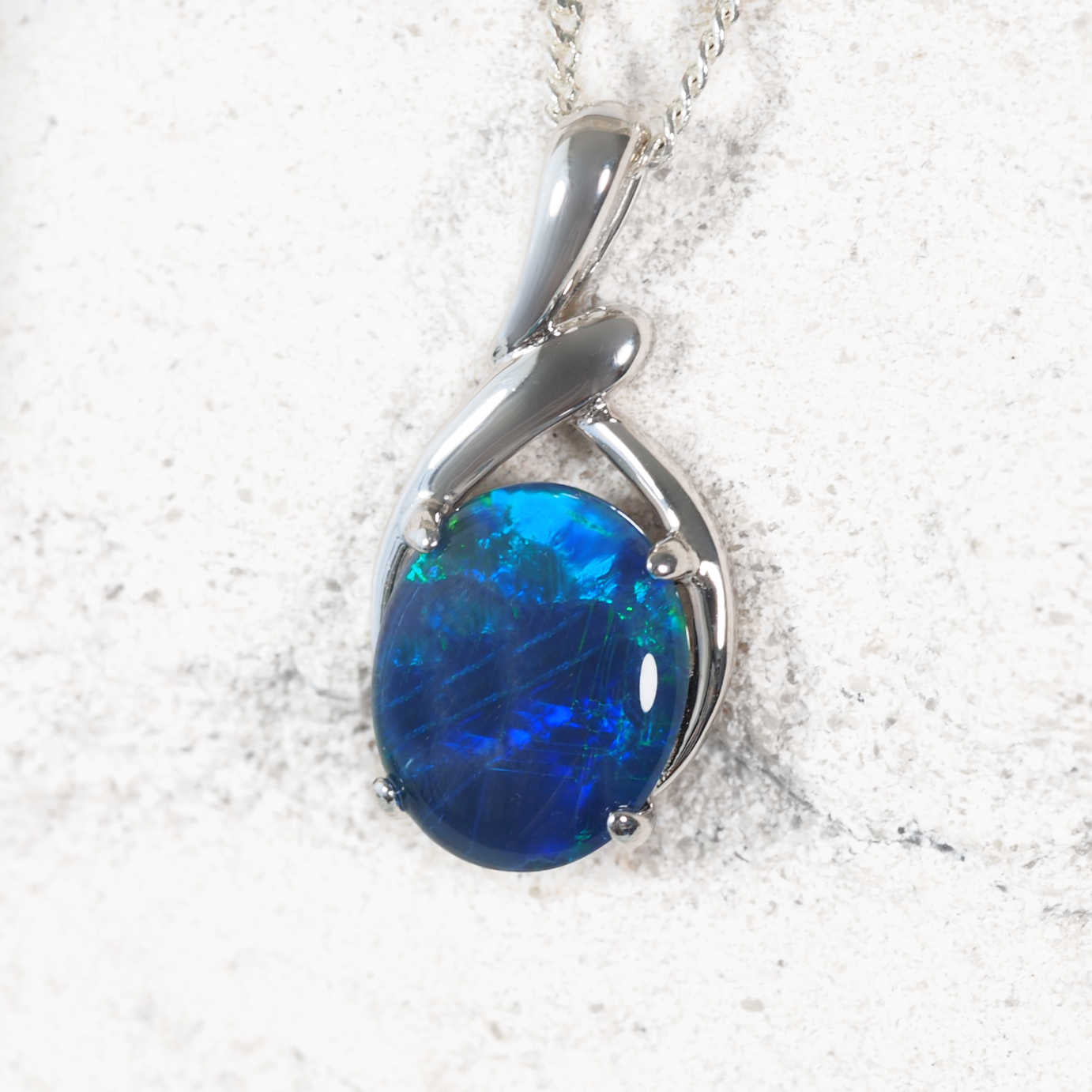 Elegant sterling silver opal necklace pendant featuring claw-set oval Australian triplet opal glowing with blue and green flashes