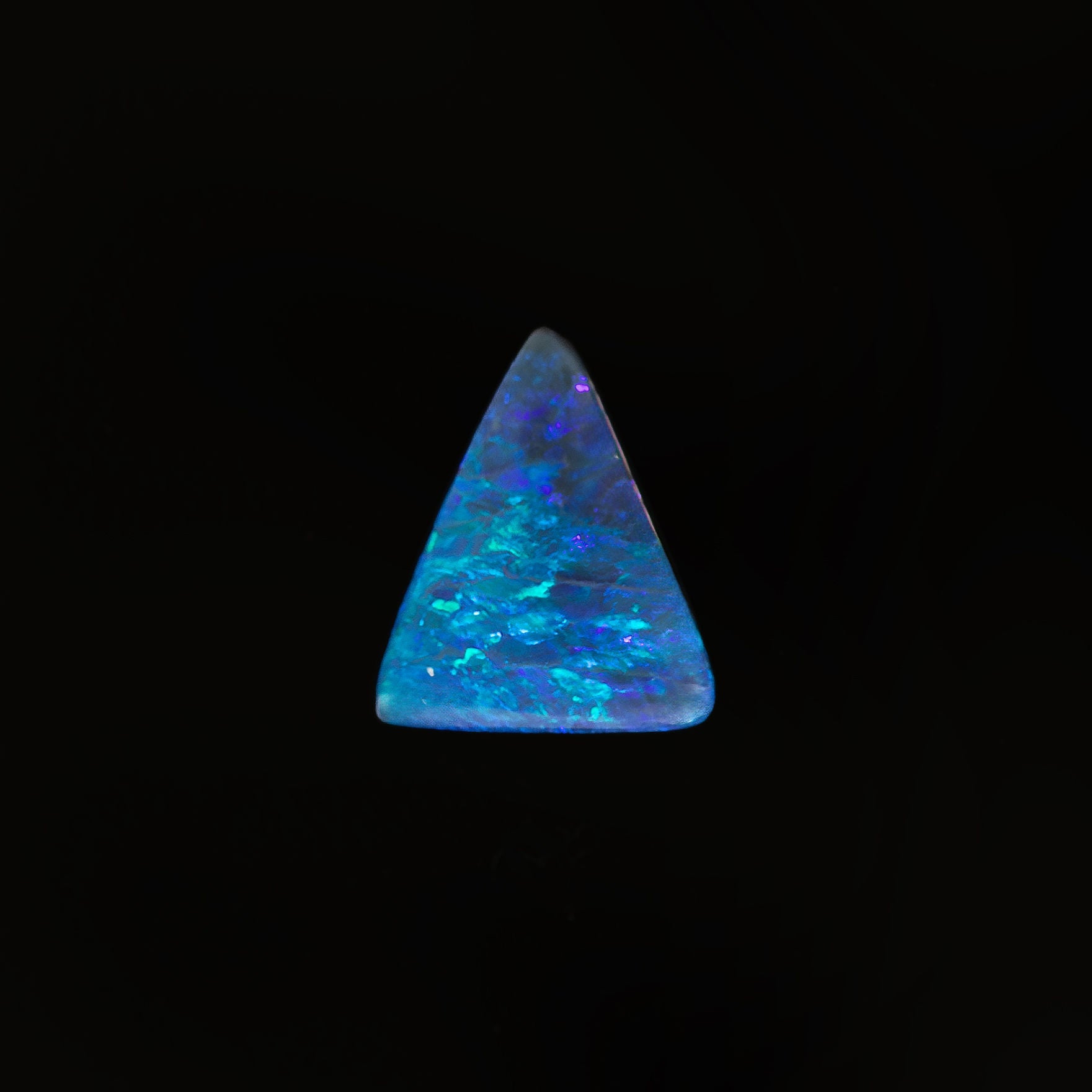 Triangular black opal featuring vibrant blue and green play of colour.