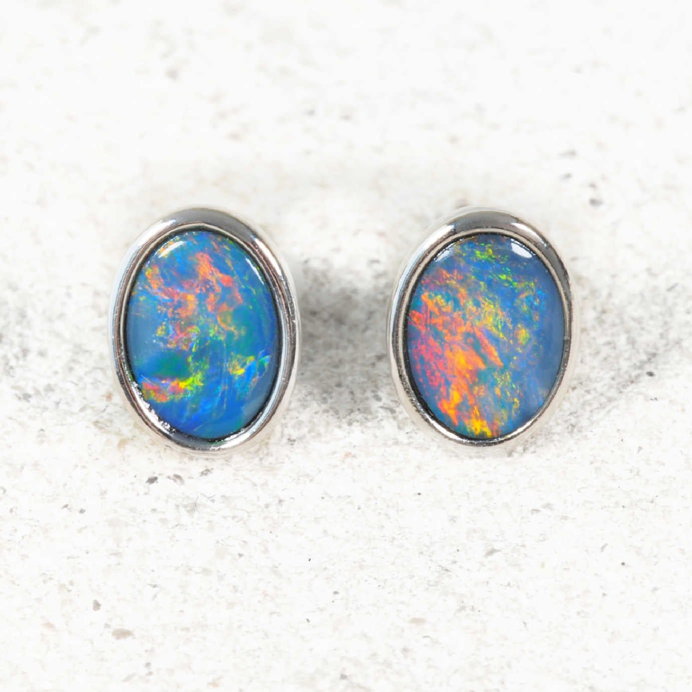 Oval bezel-set opal silver studs with multi-colour flashes