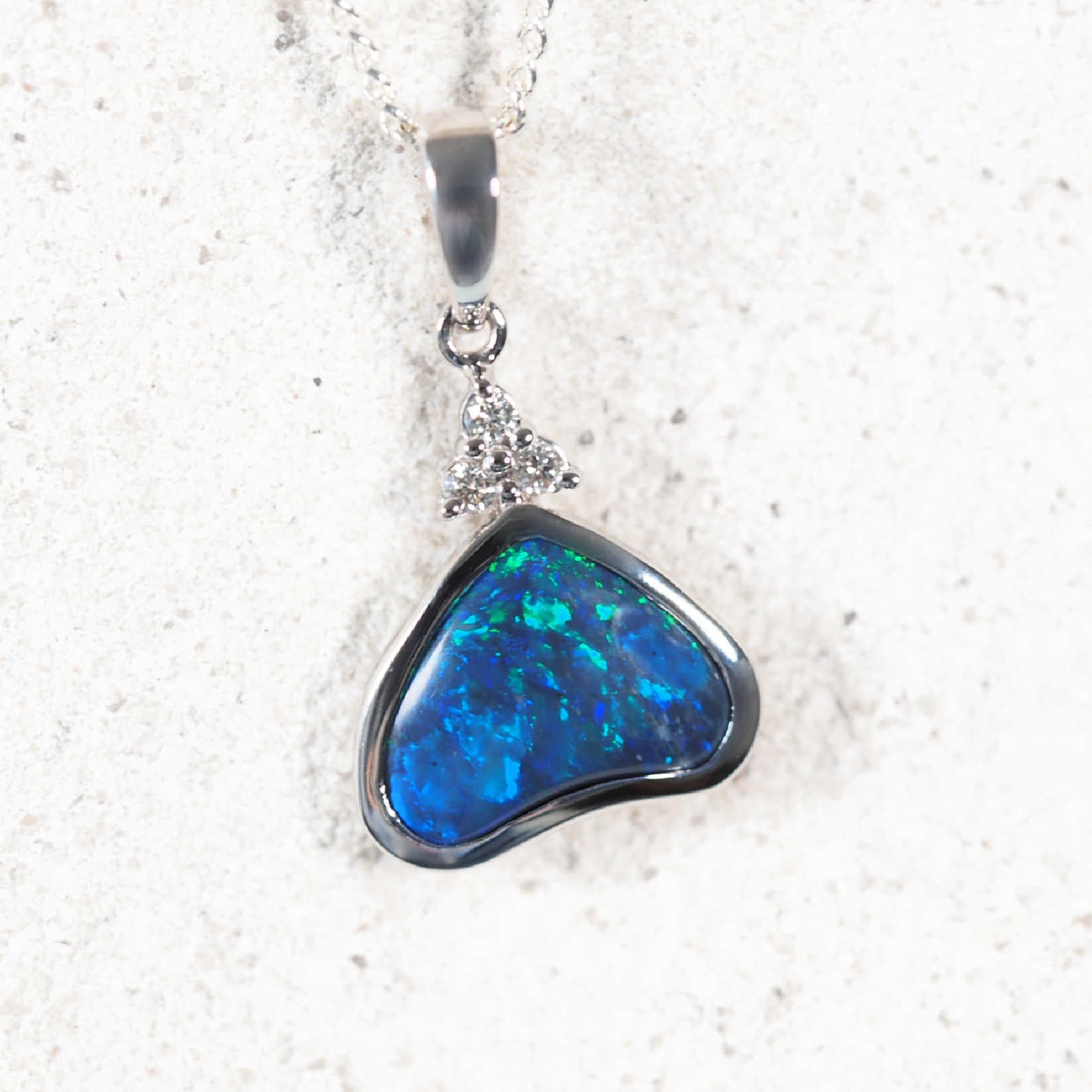 Triangular Lightning Ridge black opal pendant with vivid blue-green play-of-colour in 18ct white gold setting