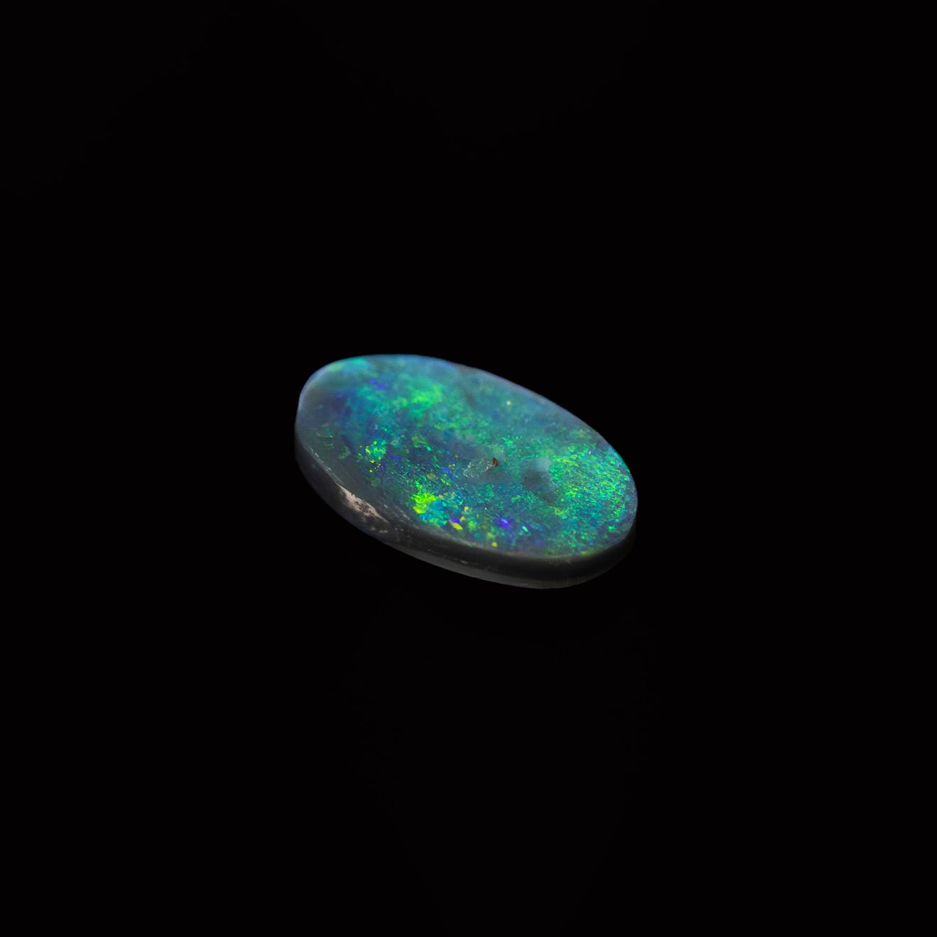 Ethically sourced Lightning Ridge black opal with speckled green pattern, set in a versatile oval cut
