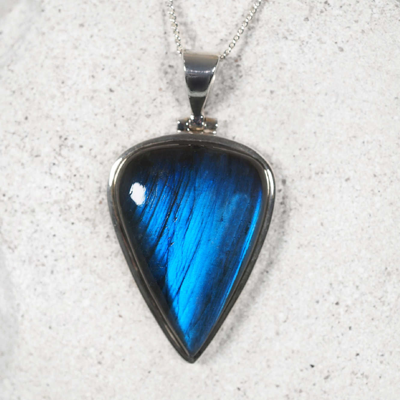 Labradorite pendant featuring an upside-down teardrop Labradorite cabochon with glowing blue tones