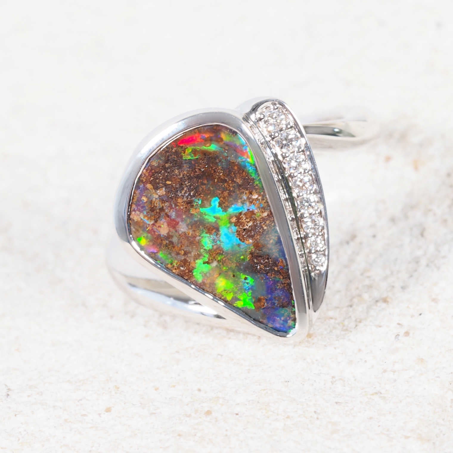 Elegant Australian boulder opal ring with bezel-set opal and eight white diamonds