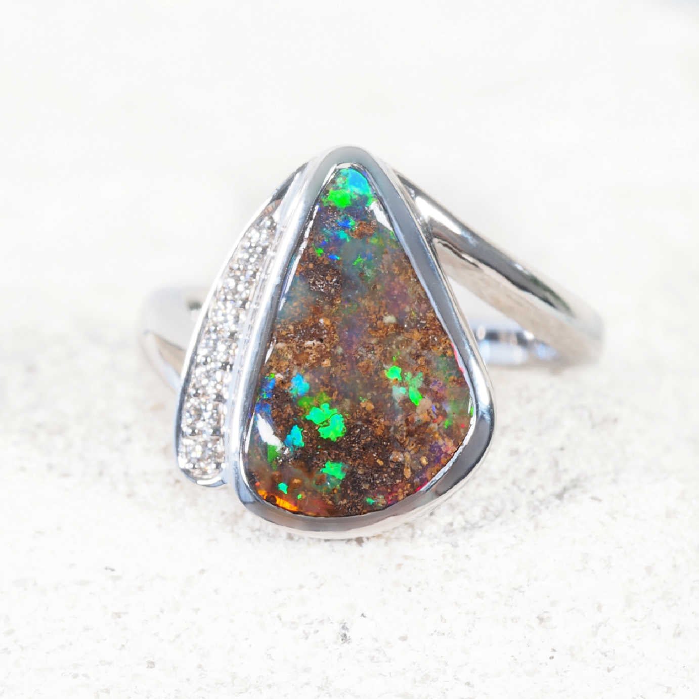 Close-up of ‘Soraya’ boulder opal ring highlighting undulating opal surface and vibrant multi-colour fire