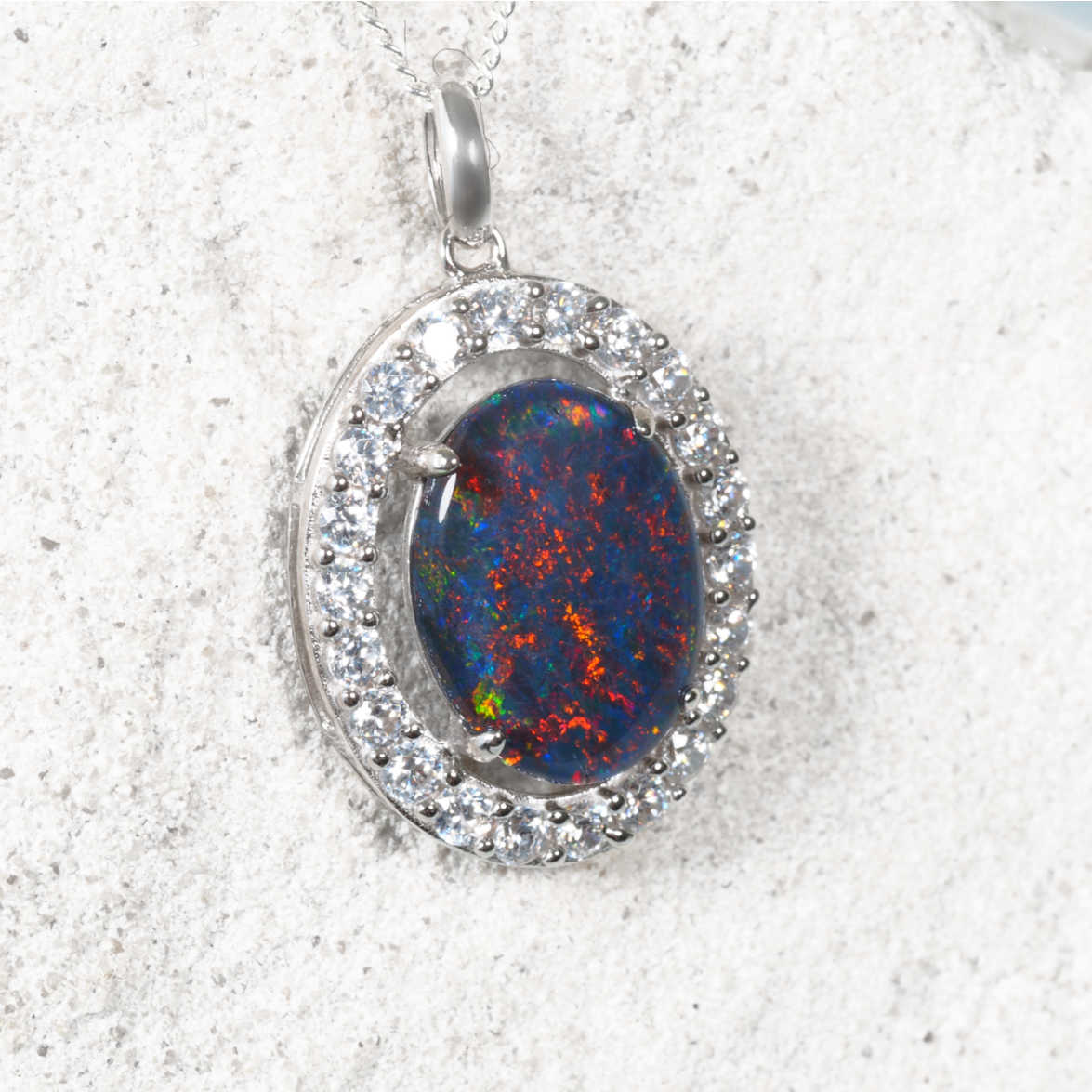 Halo-style silver opal necklace with a colourful oval Australian triplet opal and sparkling cubic zirconia border